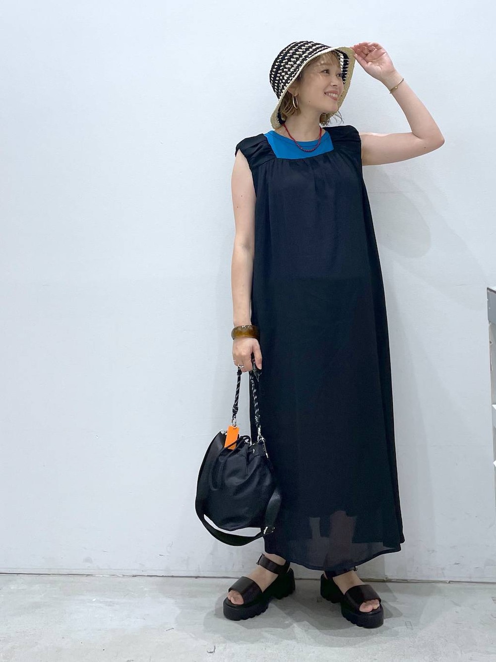 ブルー系のTシャツ/カットソー、ブラウン系のサンダル、ブラック系のショルダーバッグを着用したレディースの夏コーディネートの1枚目の写真