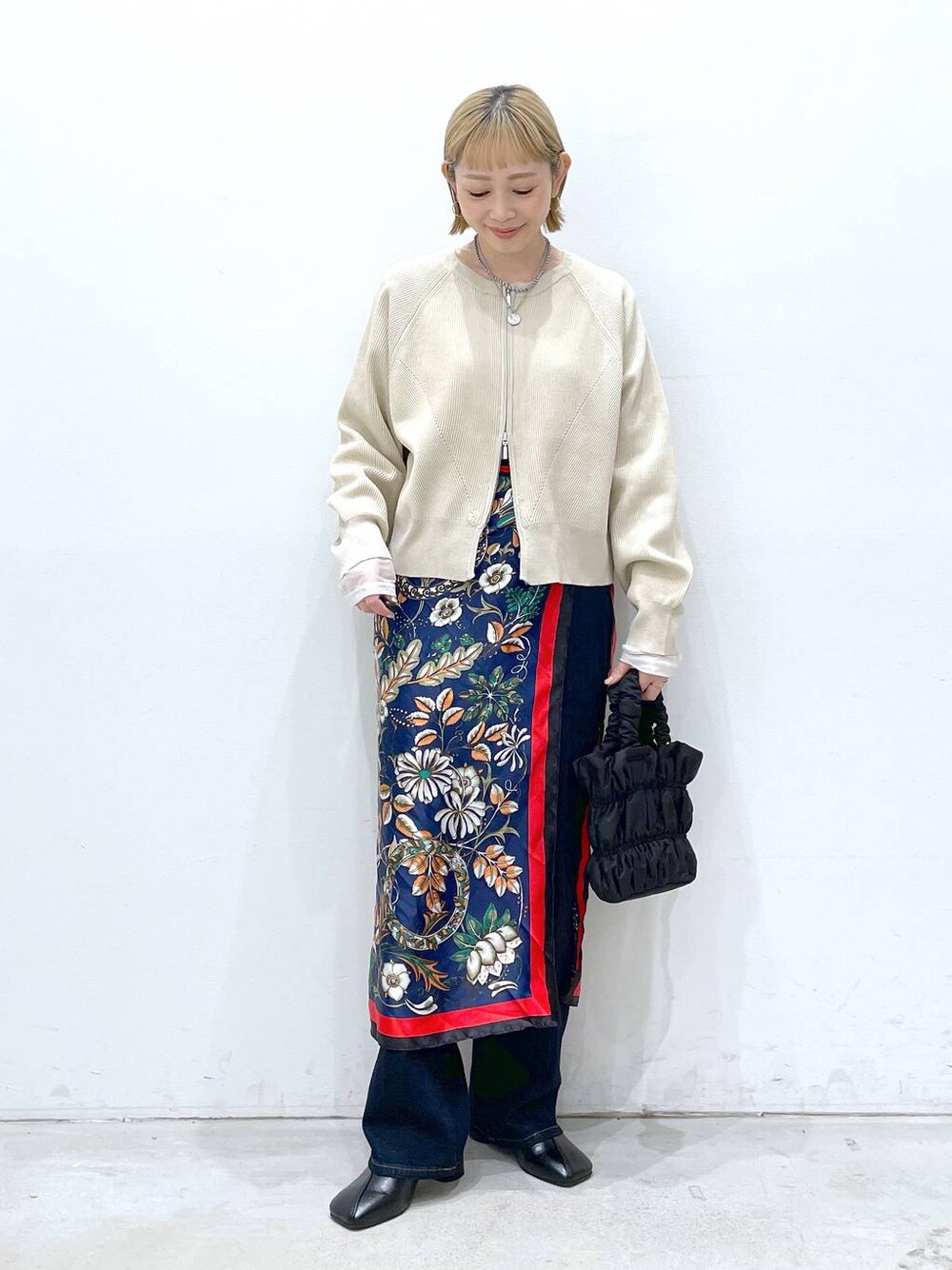 ブラック系のショルダーバッグ、ブラック系のパンプス、ブルー系のバンダナ/スカーフを着用したレディースの冬コーディネートの1枚目の写真