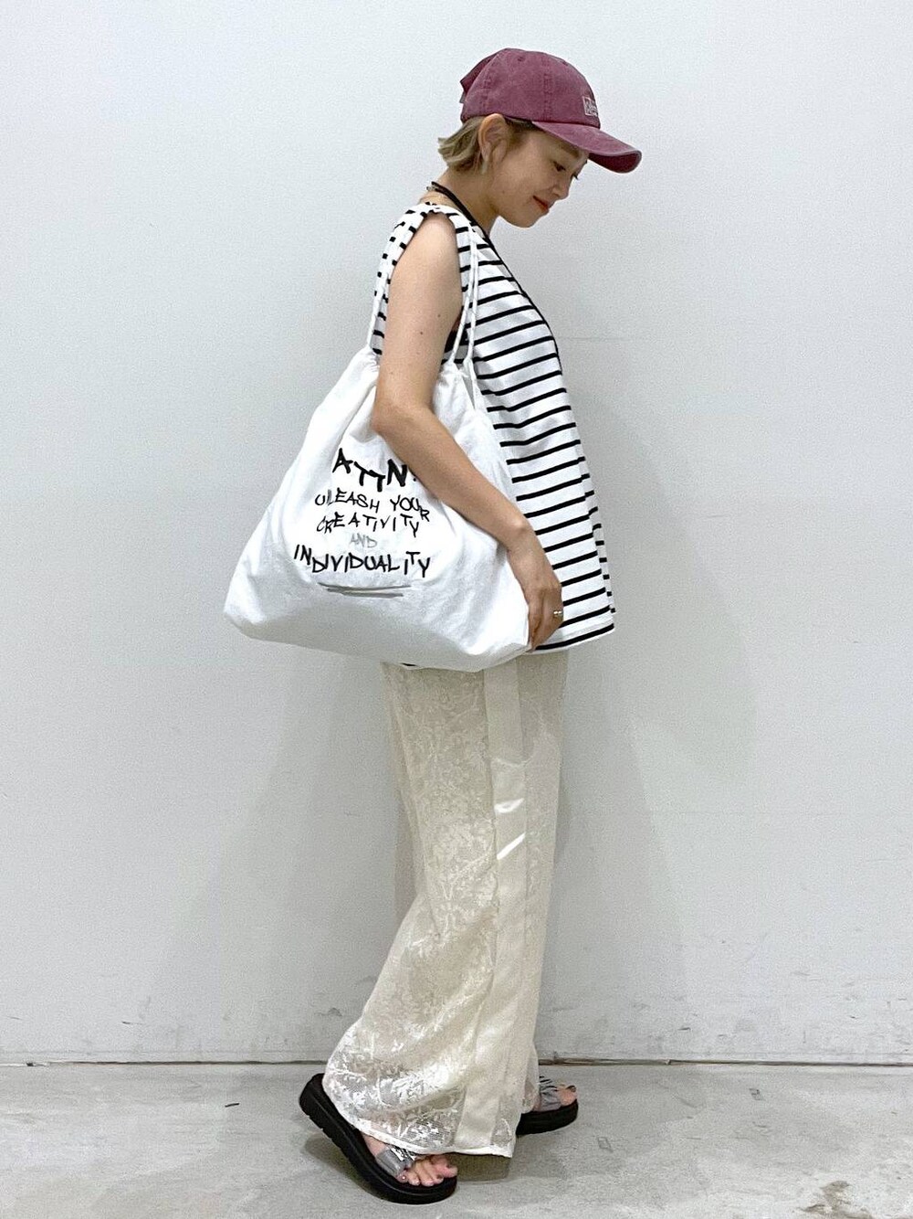 シルバー系のサンダル、ホワイト系のTシャツ/カットソー、ホワイト系のショルダーバッグを着用したレディースの夏コーディネートの1枚目の写真