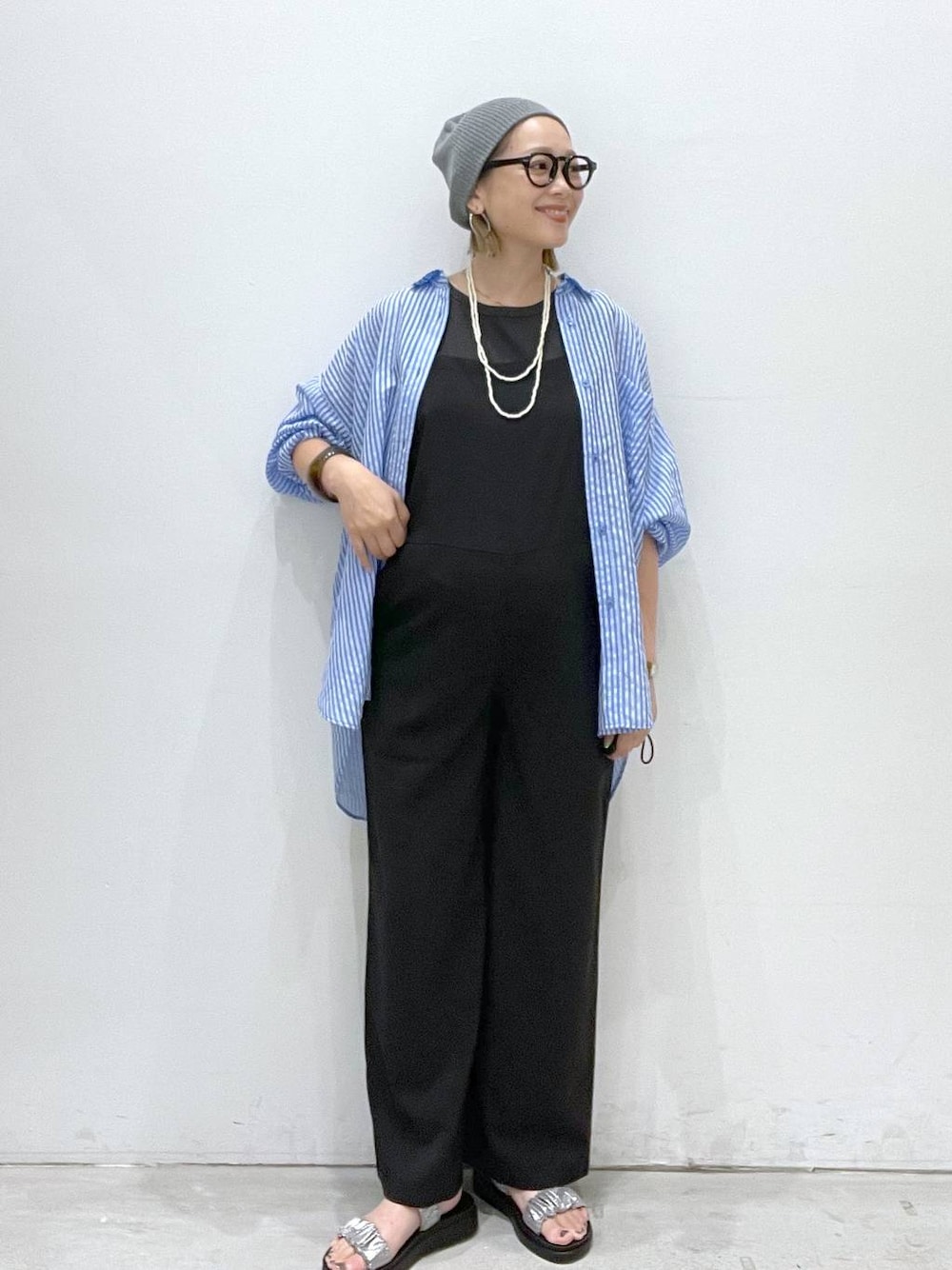 グレー系のタンクトップ、シルバー系のサンダル、ブラック系のサロペット/オーバーオールを着用したレディースの夏コーディネートの1枚目の写真