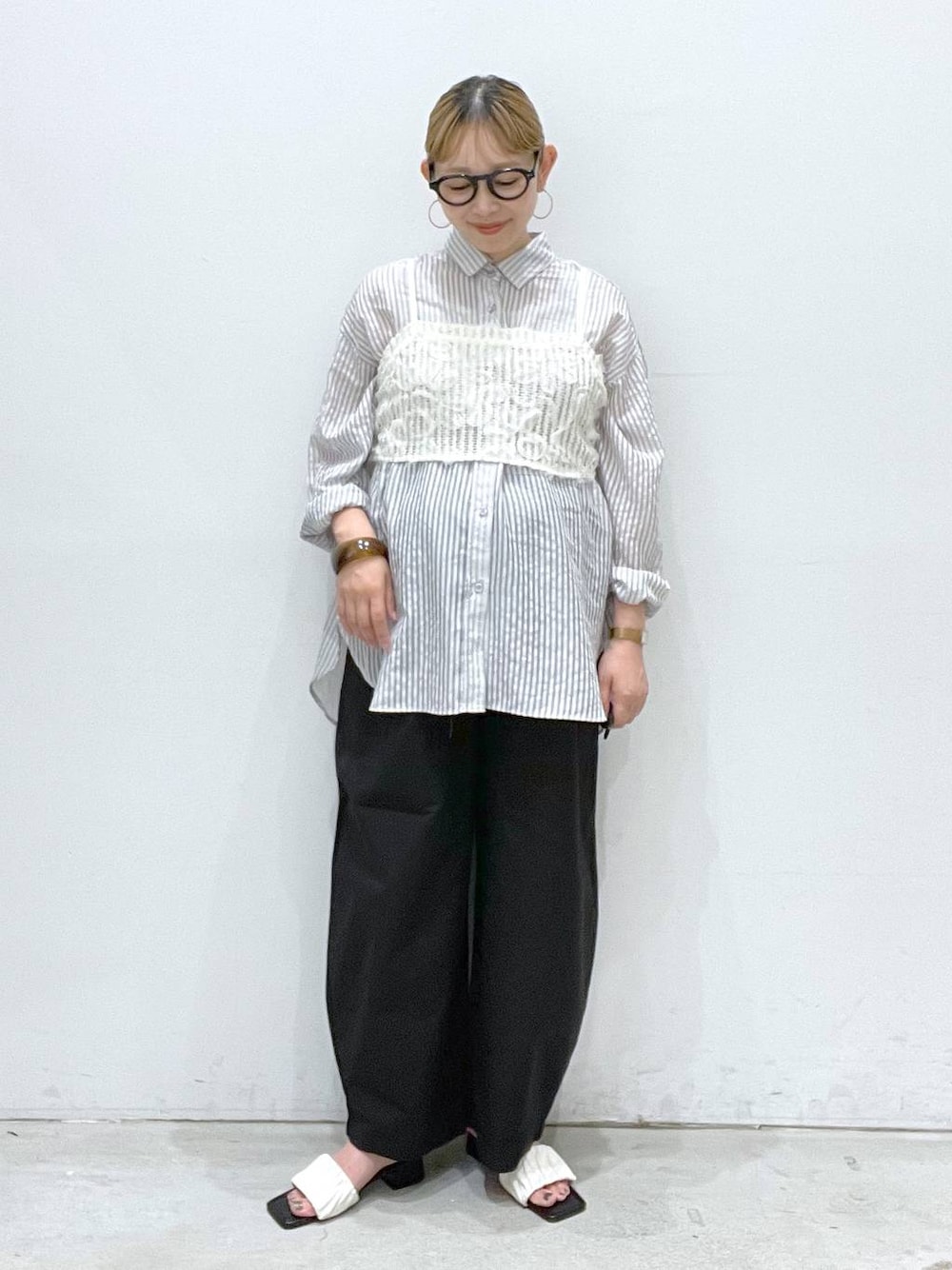 ブラック系のその他パンツ、ホワイト系のサンダル、ホワイト系のキャミソールを着用したレディースの夏コーディネートの1枚目の写真