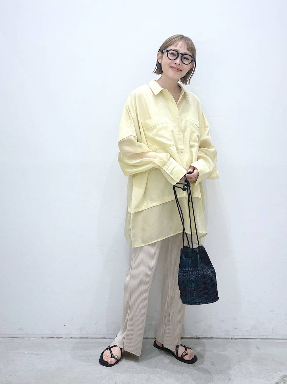 ブラック系のショルダーバッグ、イエロー系のシャツ/ブラウス、ベージュ系のその他パンツを着用したレディースの夏コーディネートの1枚目の写真