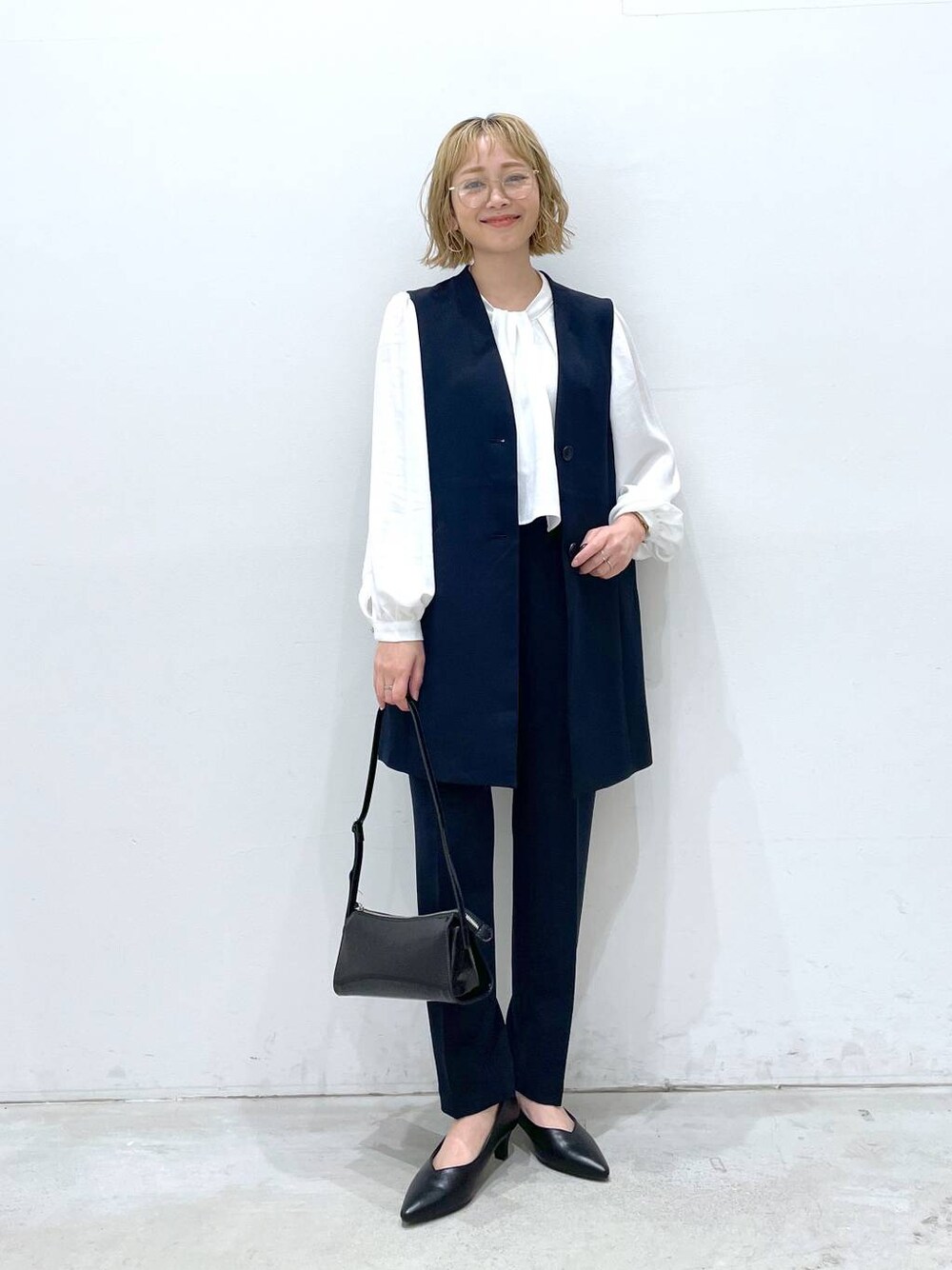 ブルー系のスーツパンツ、ホワイト系のシャツ/ブラウス、ブルー系のスーツベストを着用したレディースの冬コーディネートの1枚目の写真