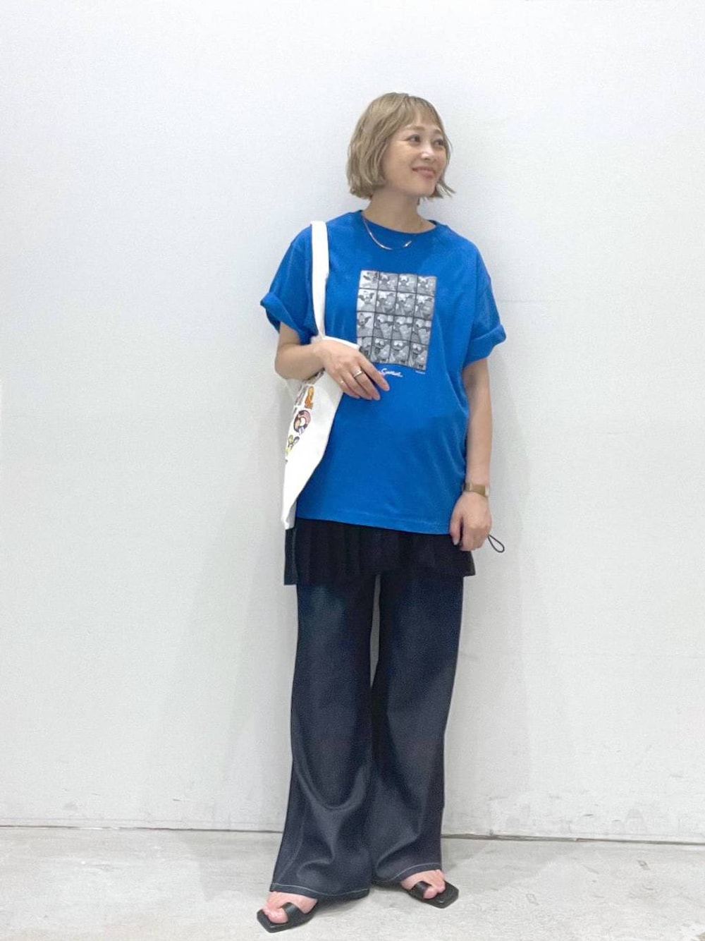 ブルー系のデニムパンツ、ブラック系のスカート、ブラック系のサンダルを着用したレディースの夏コーディネートの1枚目の写真