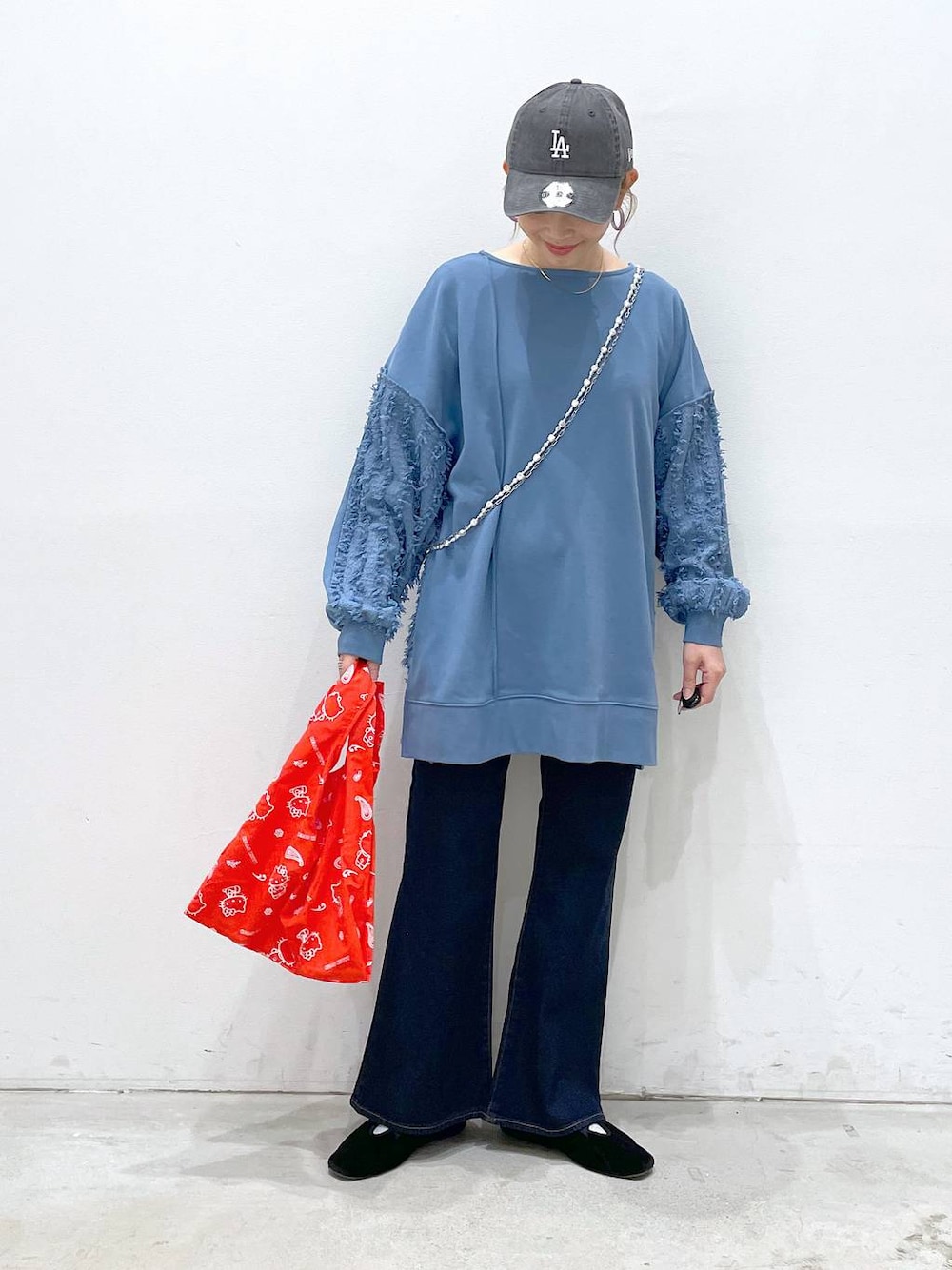 ブラック系のバレエシューズ、ブルー系のデニムパンツ、レッド系のエコバッグ/サブバッグを着用したレディースの冬コーディネートの1枚目の写真