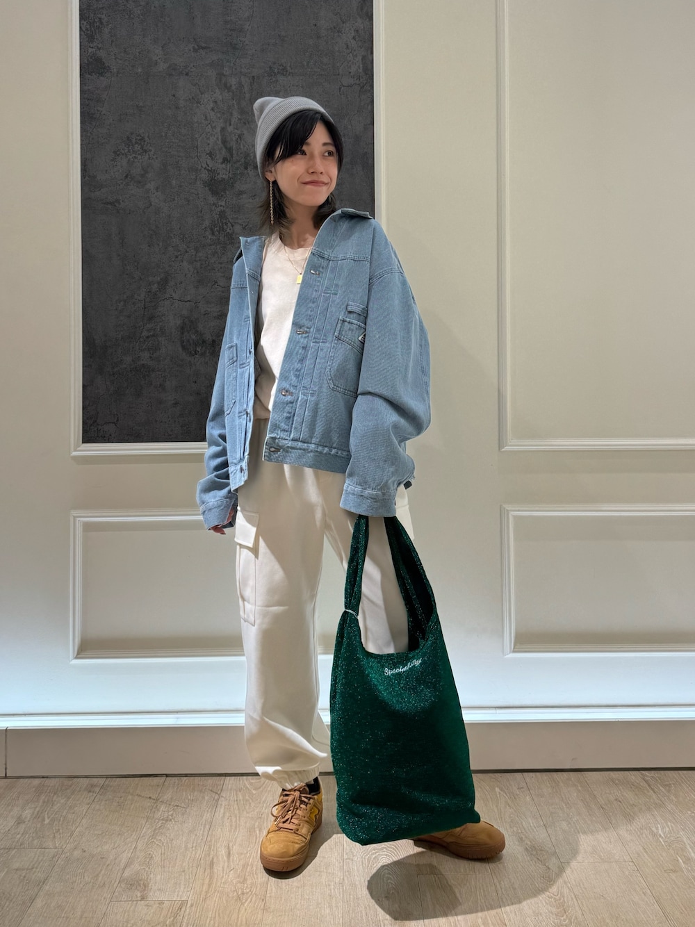 ブルー系のデニムジャケット、オレンジ系のトートバッグ、ホワイト系のカーゴパンツを着用したレディースの冬コーディネートの1枚目の写真