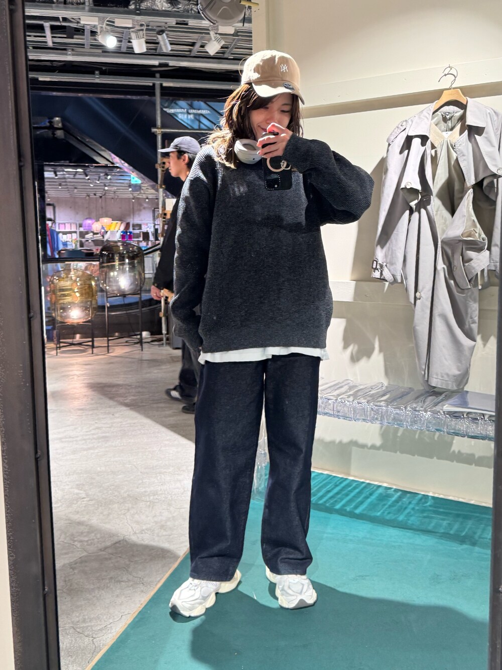 グレー系のニット/セーター、ブルー系のデニムパンツを着用したレディースの冬コーディネートの1枚目の写真