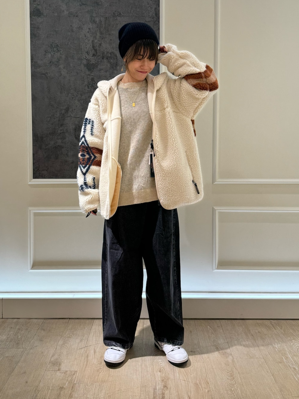 ホワイト系のブルゾン、ブラック系のデニムパンツ、ブラック系のニットキャップ/ビーニーを着用したレディースの秋コーディネートの1枚目の写真