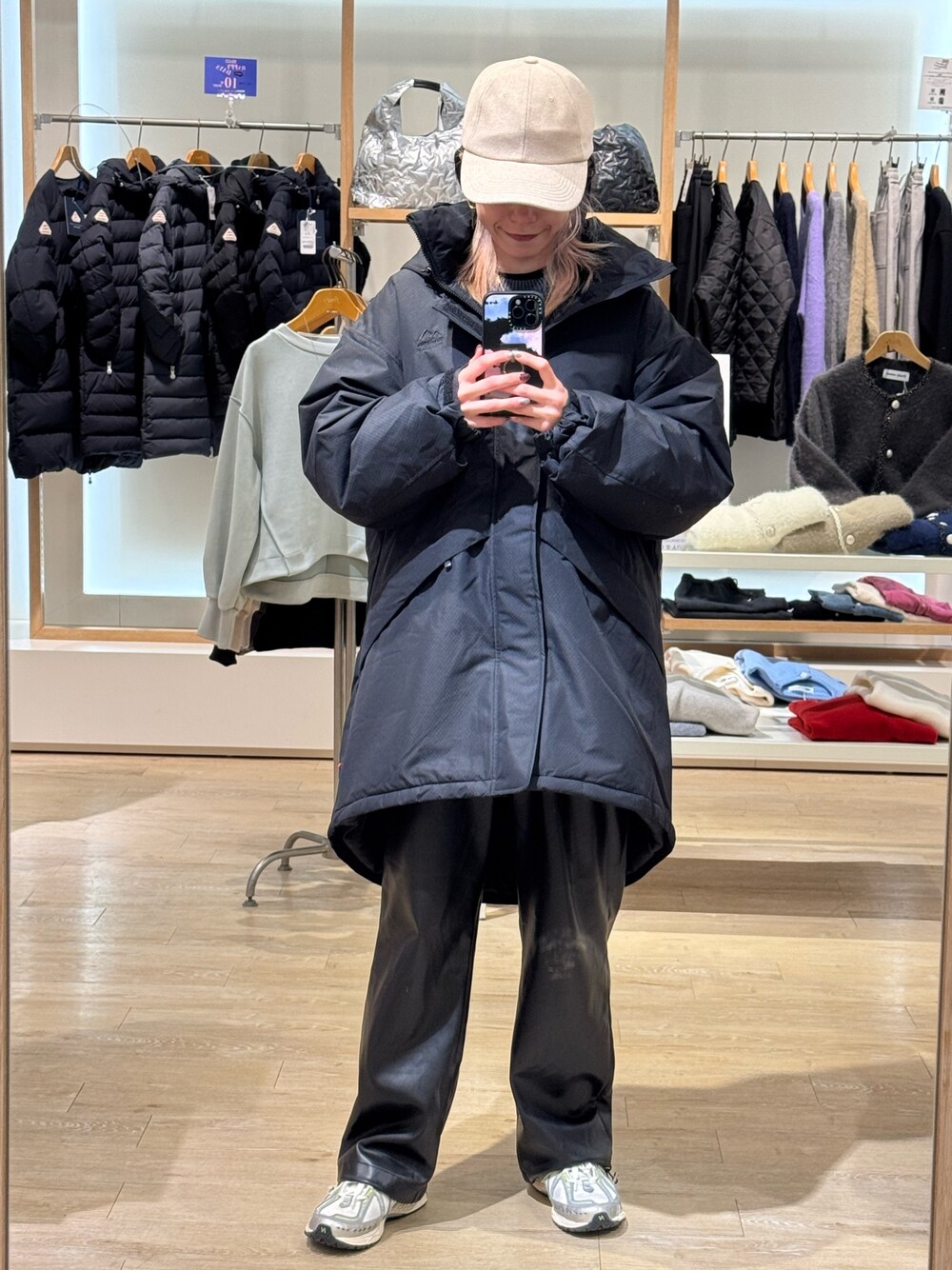 ブラック系のダウンジャケット/コート、ブルー系のキャップを着用したレディースの秋コーディネートの1枚目の写真