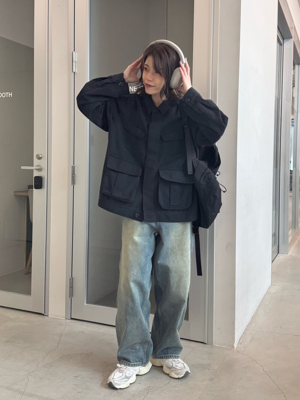 ブラック系のブルゾン、ブルー系のデニムパンツ、ブラック系のバックパック/リュックを着用したレディースの冬コーディネートの1枚目の写真