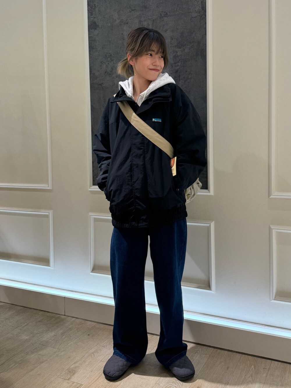 ブラック系のナイロンジャケット、ブラック系のデニムパンツ、ホワイト系のパーカーを着用したレディースの秋コーディネートの1枚目の写真