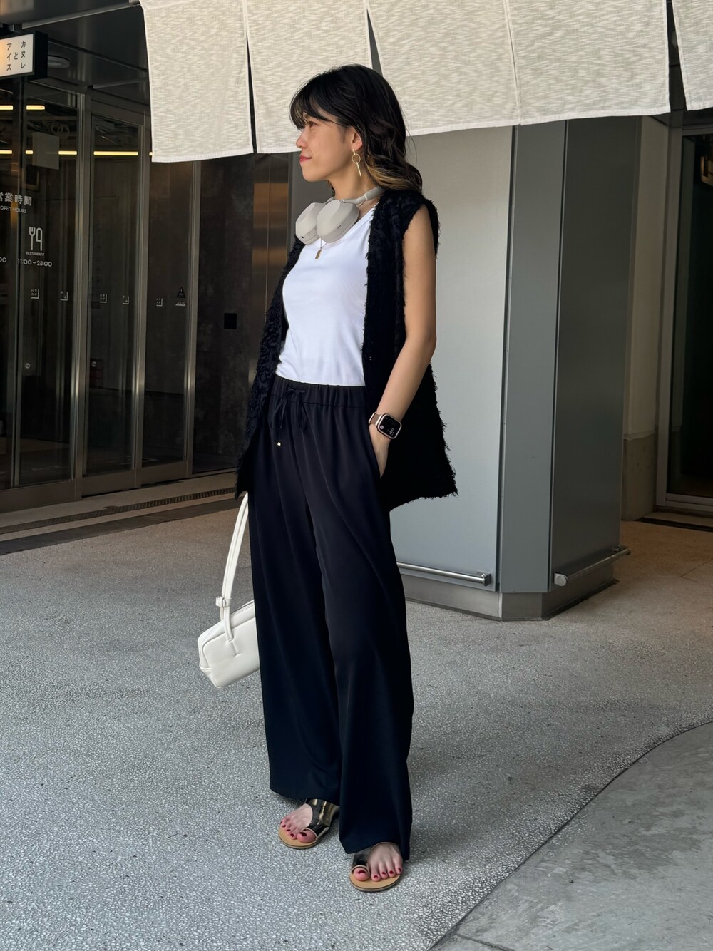 ブラック系のベスト、グレー系のその他パンツ、シルバー系のサンダルを着用したレディースの夏コーディネートの1枚目の写真