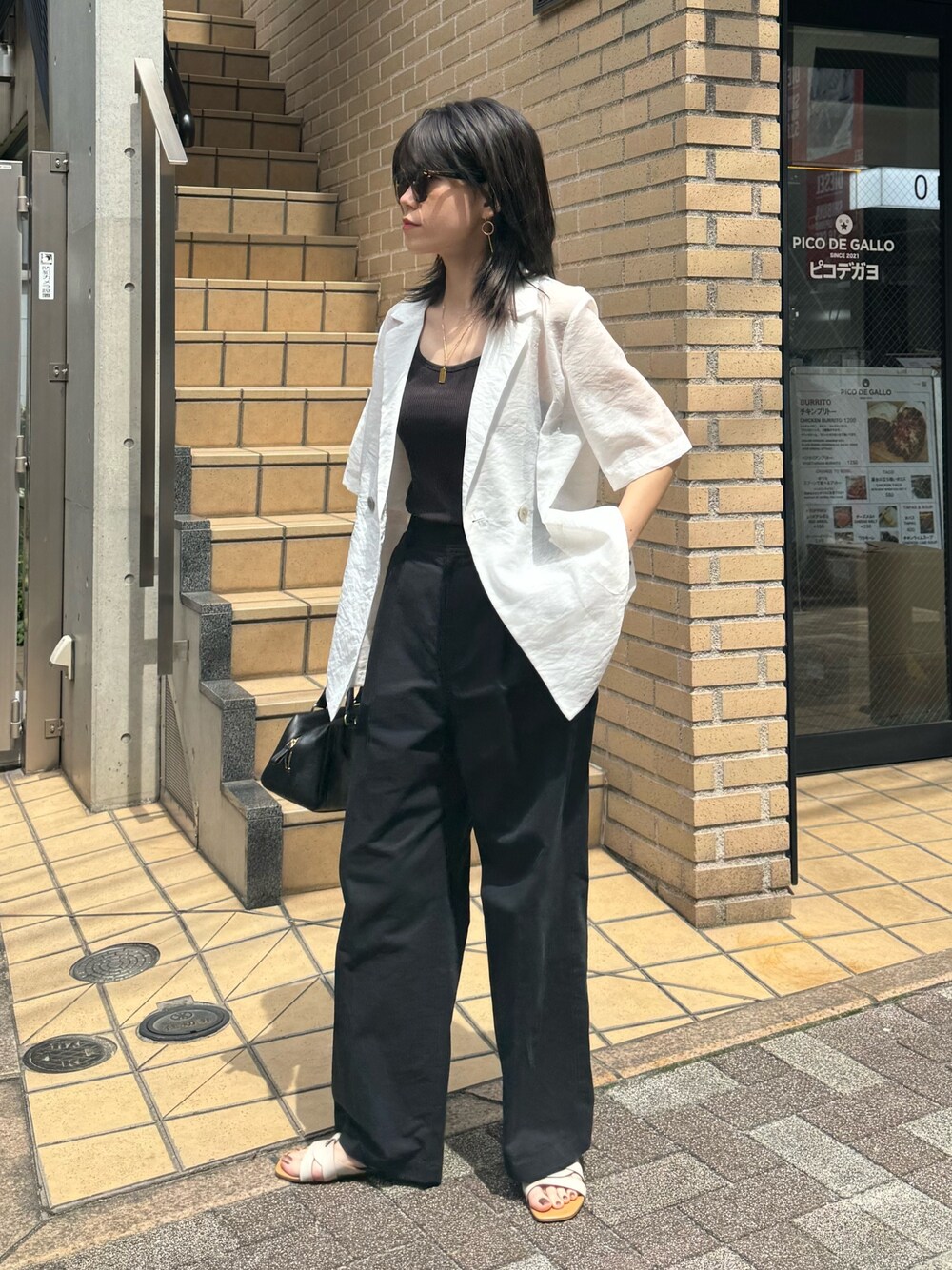 ホワイト系のダウンジャケット/コート、ブラック系のチノパンツを着用したレディースの夏コーディネートの1枚目の写真