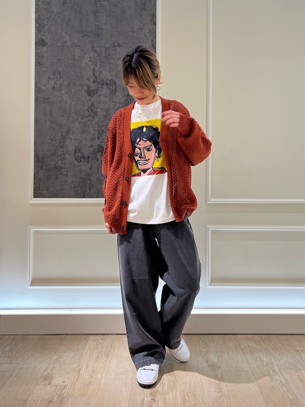 オレンジ系のカーディガン/ボレロ、ブラック系のデニムパンツを着用したレディースの秋コーディネートの1枚目の写真