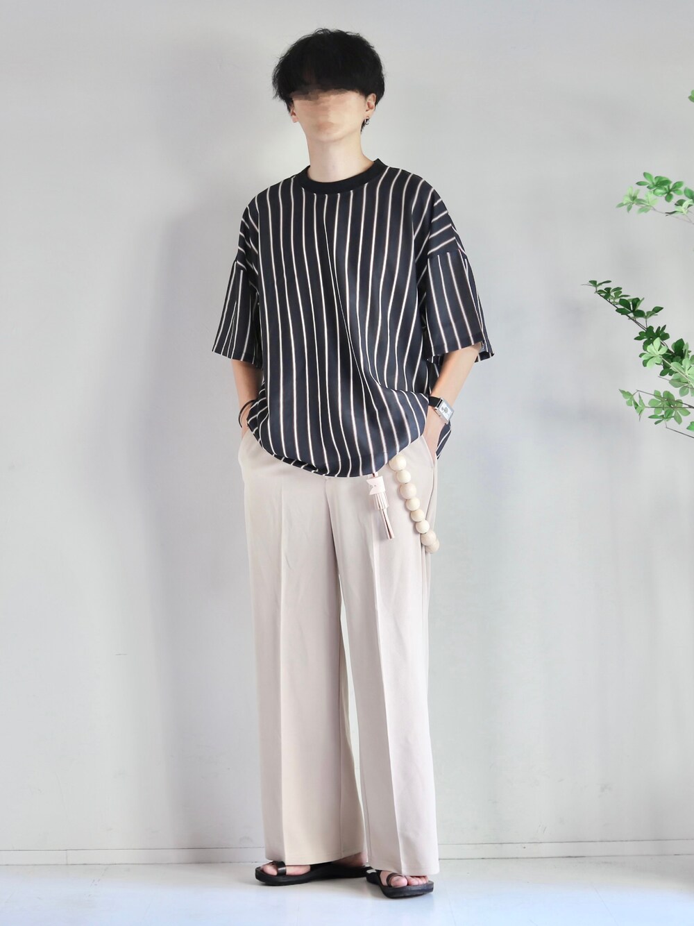 ブラック系のTシャツ/カットソー、ホワイト系のスラックス、ブラック系のサンダルを着用したメンズの夏コーディネートの1枚目の写真