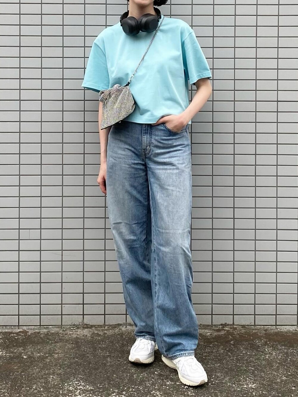 ホワイト系のスニーカー、グレー系のデニムパンツ、シルバー系のバッグを着用したレディースの春コーディネートの1枚目の写真