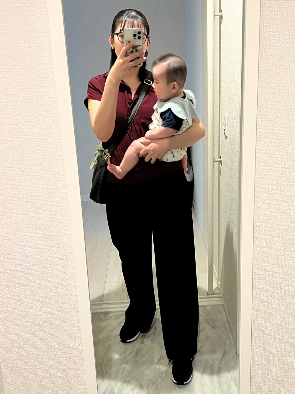 ブラック系のスニーカー、ブラック系のスラックス、グレー系のトートバッグを着用したレディースの秋コーディネートの1枚目の写真