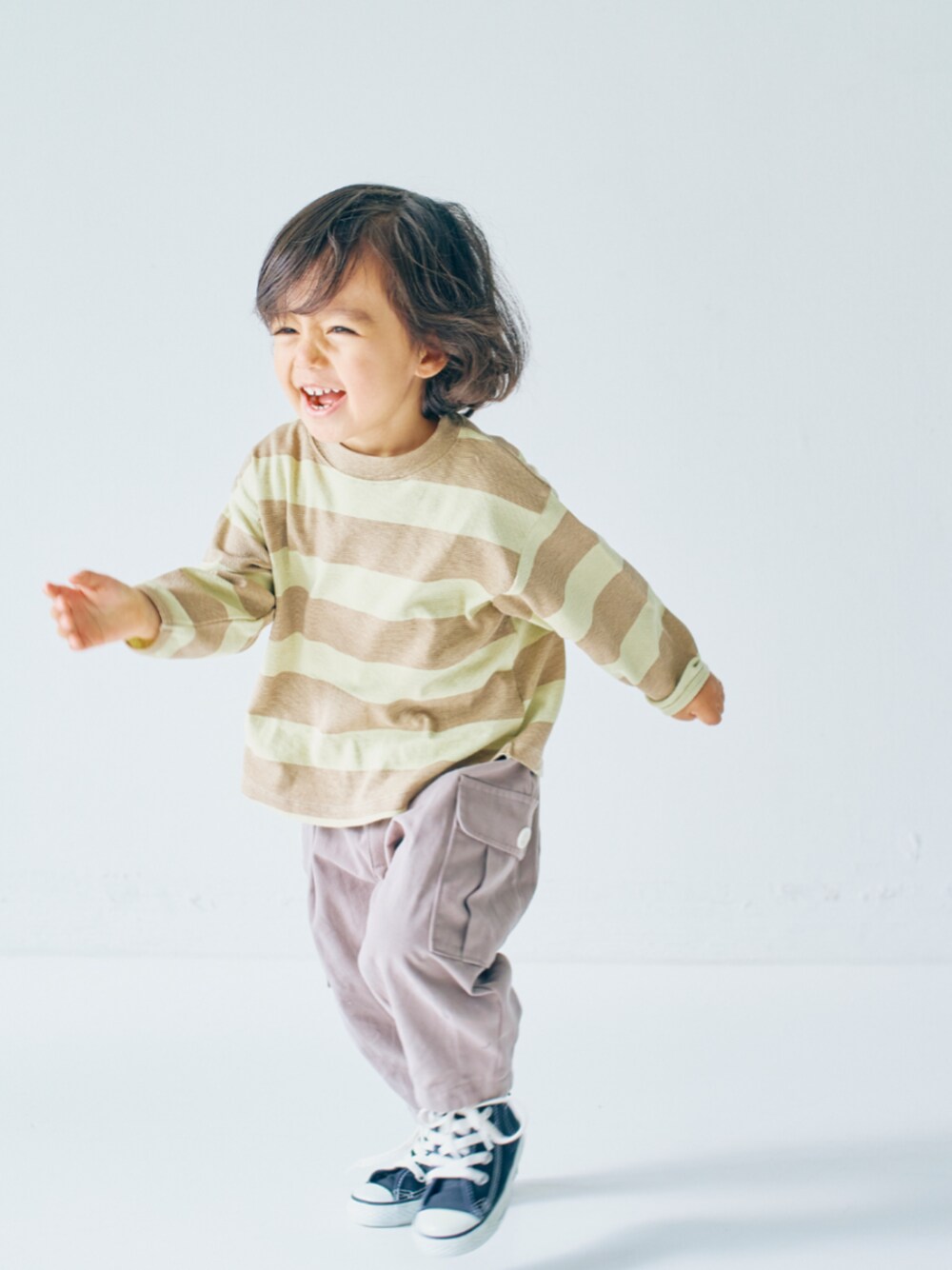 ベージュ系のTシャツ/カットソー、グレー系のカーゴパンツを着用したキッズの冬コーディネートの1枚目の写真