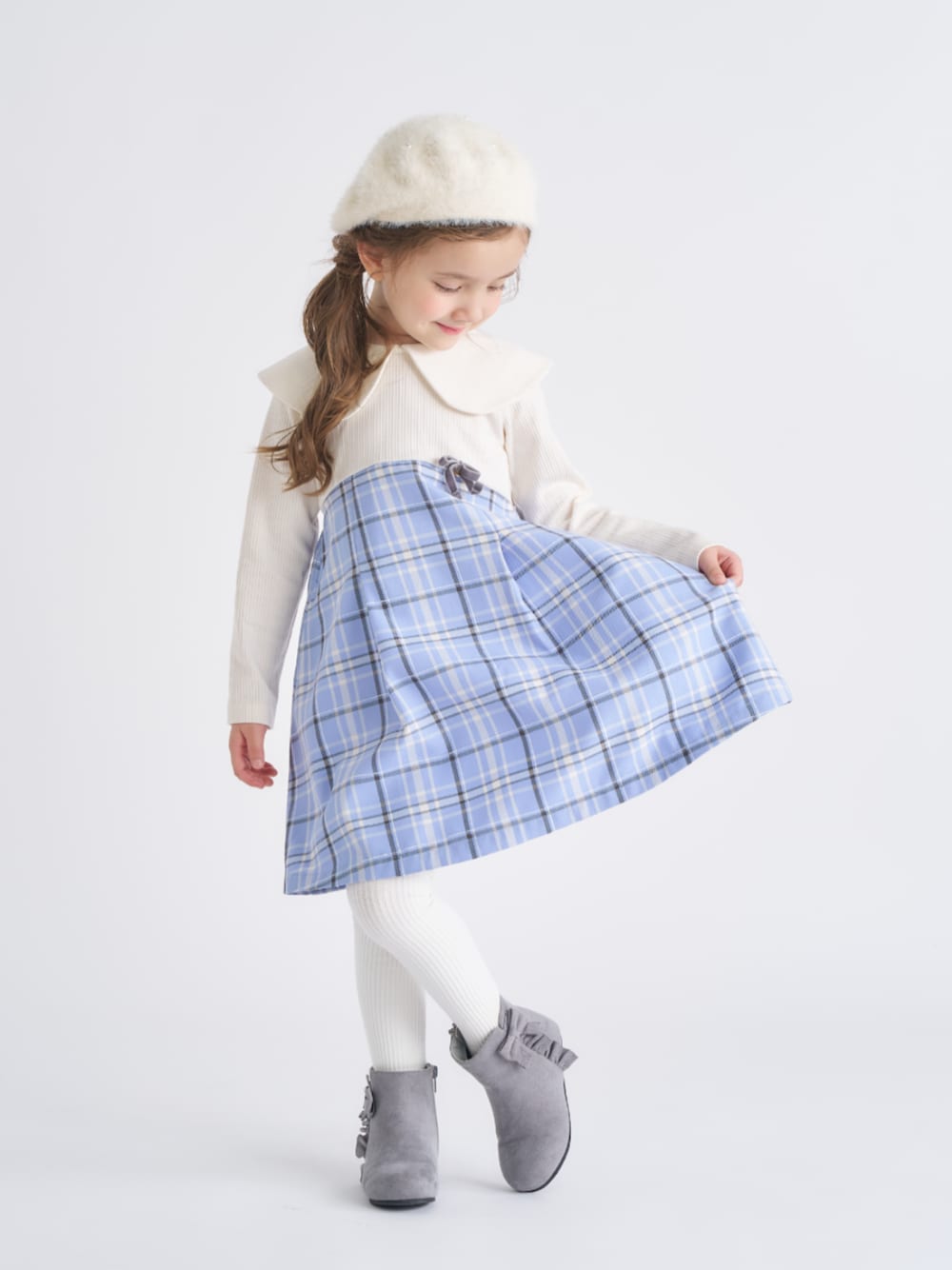 グレー系のブーツ、ブルー系のワンピース、ホワイト系のタイツ/ストッキングを着用したキッズの冬コーディネートの1枚目の写真