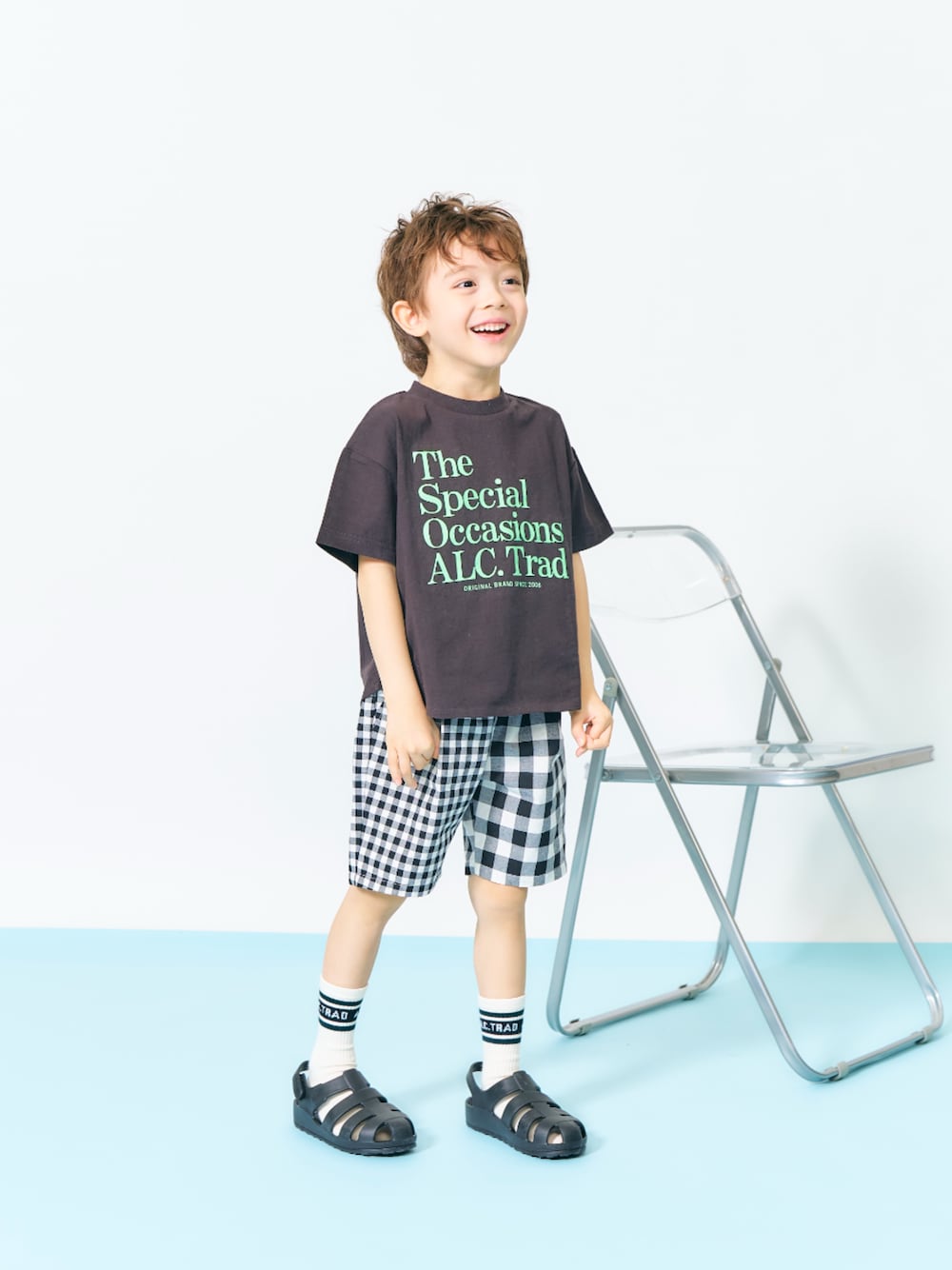 「F.O.Online Store、エフオーオンラインストア(F.O.Online Store)、apres les cours、アプレレクール、キッズコーデ、キッズファッション、男の子、ユニセックス、ロゴT、ハーフパンツ、チェック、靴下チラ見せ、靴下 × サンダル、カジュアルコーデ、プチプラ」｜「apres les coursのALCロゴTシャツ（Tシャツ/カットソー、ブラック系）」を使った、F.O.OnlineStoreさん（キッズ・110cm）の春コーディネートの1枚目の写真