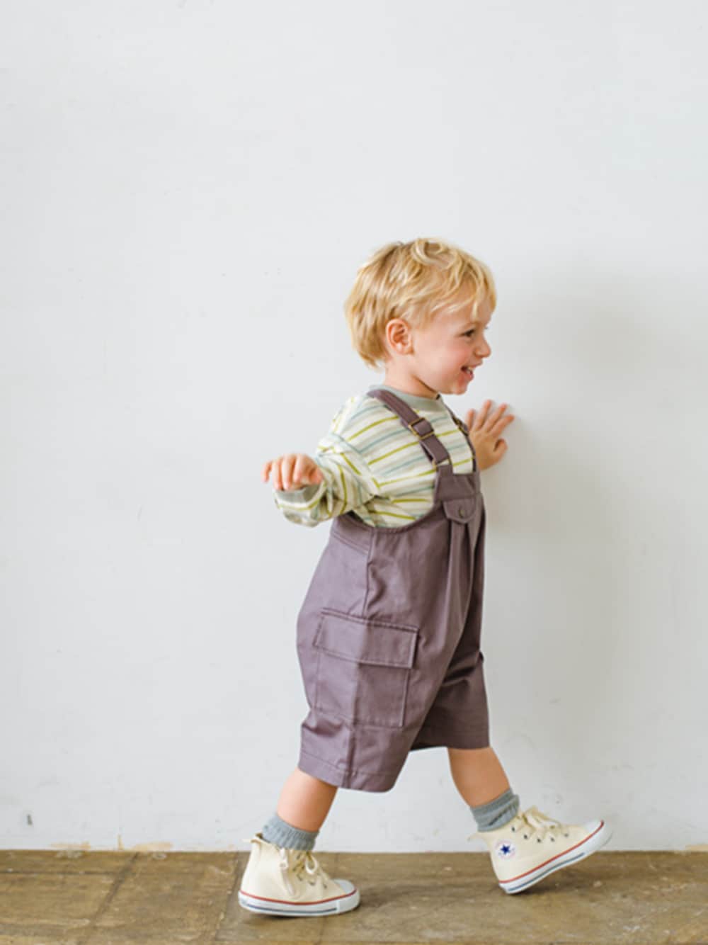 グリーン系のTシャツ/カットソー、グレー系のサロペット/オーバーオール、グレー系のソックス/靴下を着用したキッズの春コーディネートの1枚目の写真