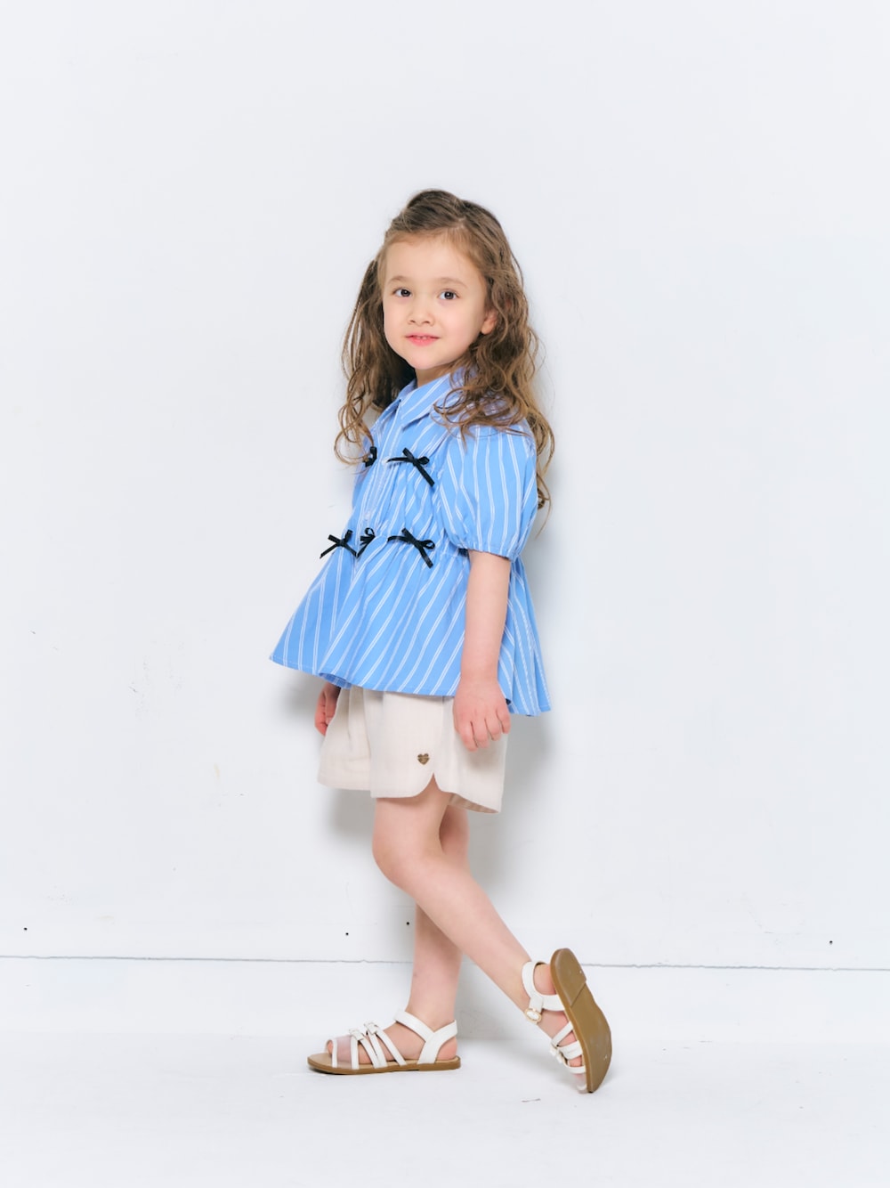「F.O.Online Store、エフオーオンラインストア(F.O.Online Store)、apres les cours、アプレレクール、キッズコーデ、キッズファッション、女の子、女の子コーデ、ストライプシャツ、リボン、ハーフパンツ、サンダル、春服、きれいめカジュアル、淡色コーデ」｜「apres les coursのリボンメッシュサンダル（サンダル、ホワイト系）」を使った、F.O.OnlineStoreさん（キッズ・110cm）の春コーディネートの1枚目の写真