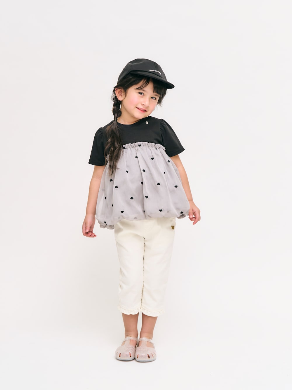 「F.O.Online Store、エフオーオンラインストア(F.O.Online Store)、apres les cours、アプレレクール、キッズコーデ、キッズファッション、女の子、女の子コーデ、パンツスタイル、サンダル、キャップ、モノトーン、お出かけコーデ、通学コーデ、きれいめカジュアル」｜「apres les coursのジェリーサンダル（サンダル、ホワイト系）」を使った、F.O.OnlineStoreさん（キッズ・110cm）の春コーディネートの1枚目の写真