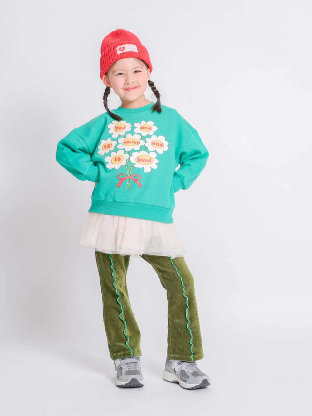 ホワイト系のチュニック、グリーン系のスウェット、グリーン系のその他パンツを着用したキッズの冬コーディネートの1枚目の写真