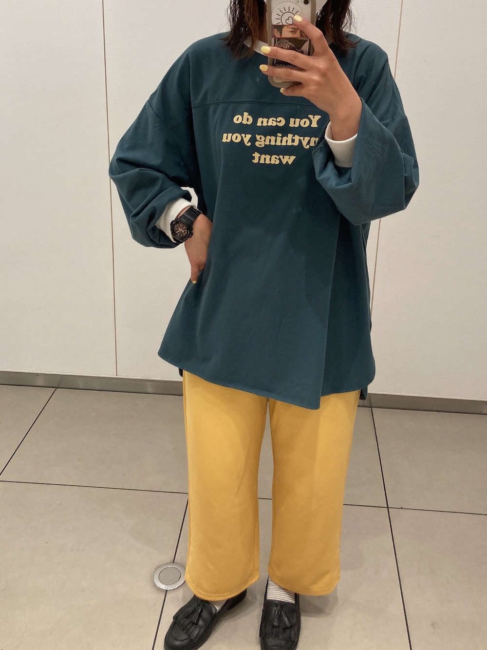 グリーン系のTシャツ/カットソー、イエロー系のパンツ、ブラック系のローファーを着用したレディースの春コーディネートの1枚目の写真