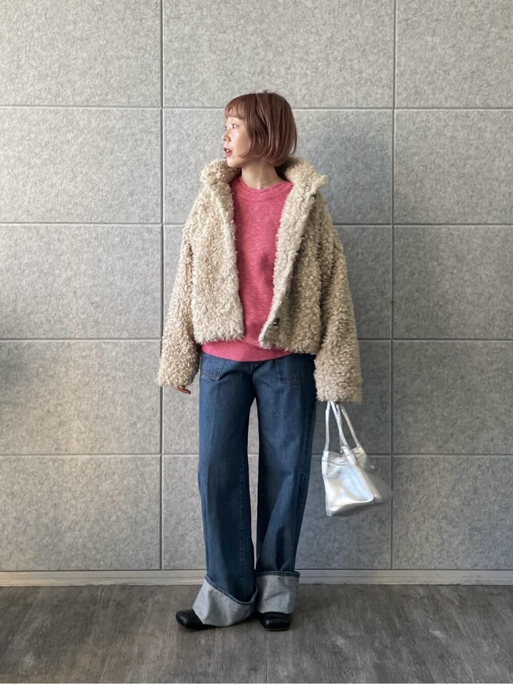 ピンク系のニット/セーター、ブルー系のデニムパンツを着用したレディースの冬コーディネートの1枚目の写真