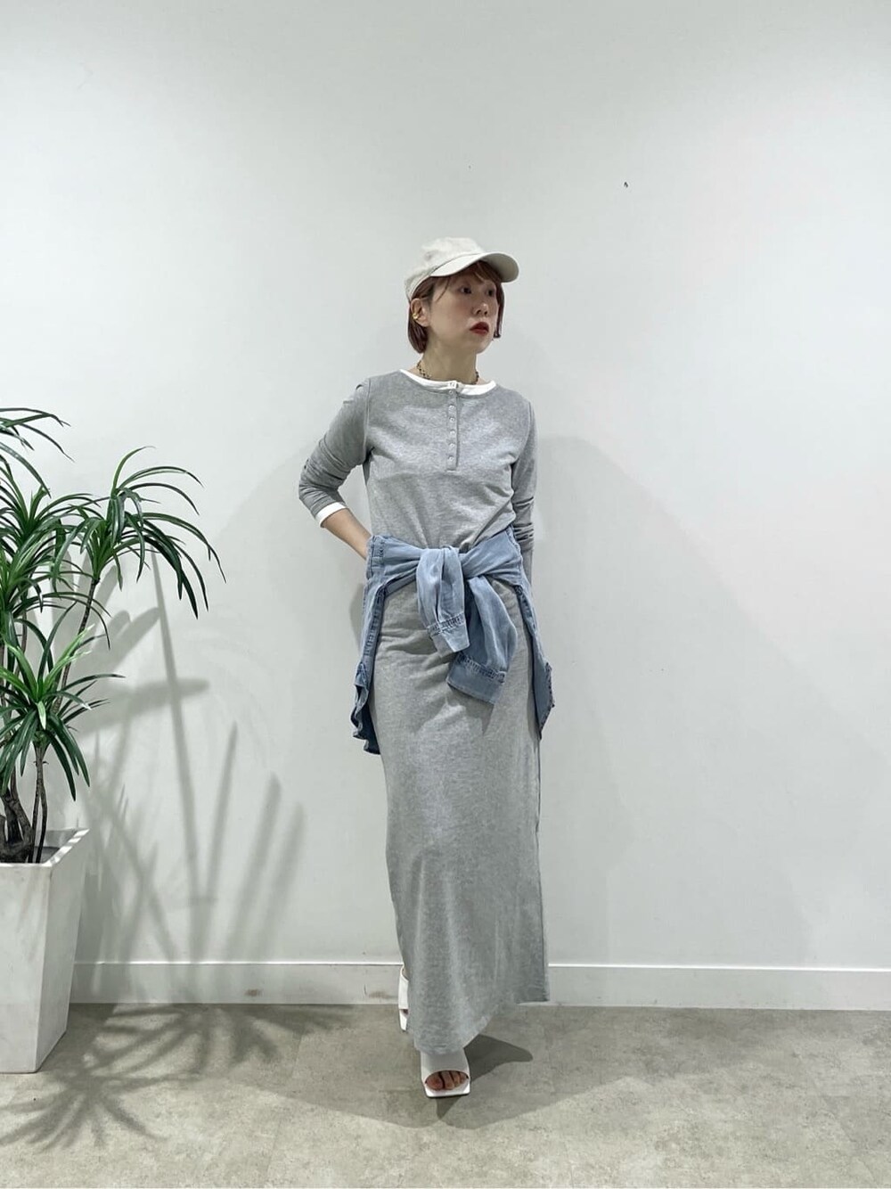 グレー系のワンピース、ホワイト系のサンダル、ブルー系のシャツ/ブラウスを着用したレディースの春コーディネートの1枚目の写真
