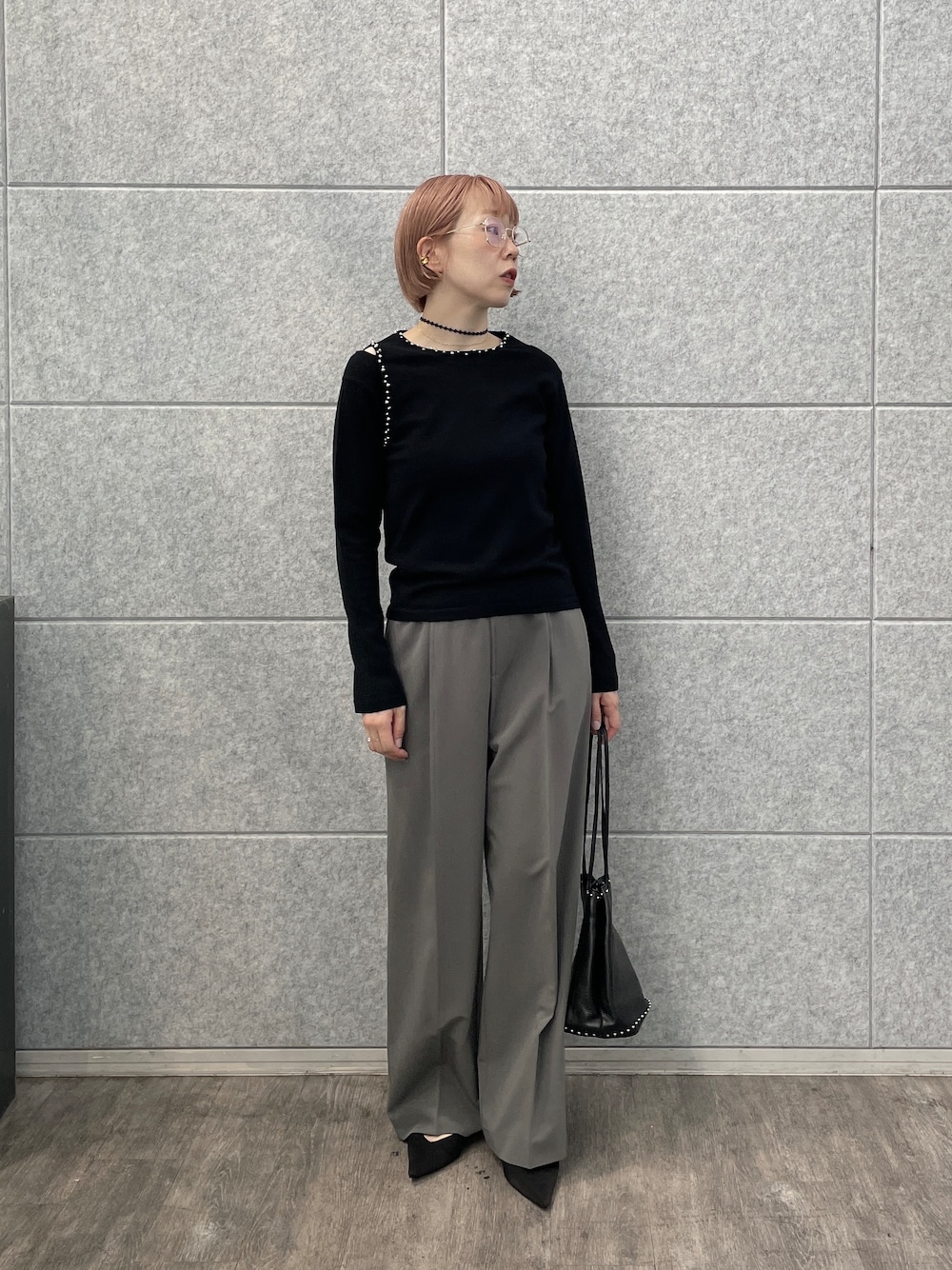 グレー系のその他パンツ、シルバー系のハンドバッグ、ブラック系のニット/セーターを着用したレディースの夏コーディネートの1枚目の写真
