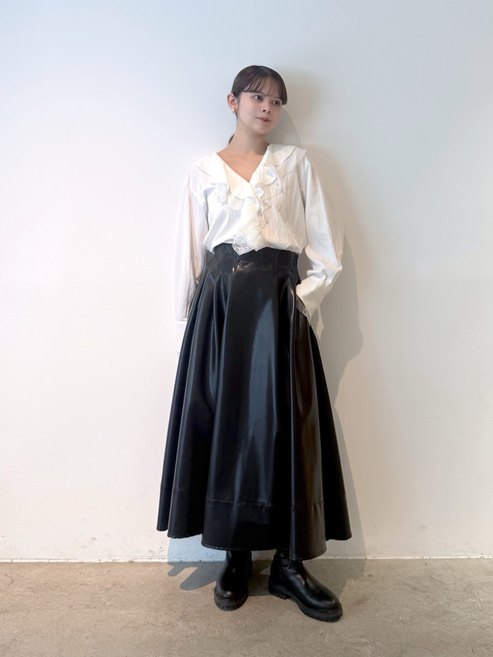 ホワイト系のシャツ/ブラウス、ブラック系のスカート、ブラック系のブーツを着用したレディースの秋コーディネートの1枚目の写真