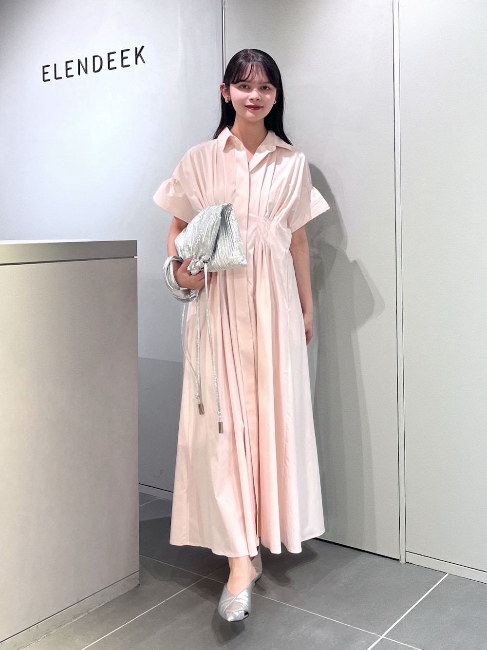 シルバー系のトートバッグ、シルバー系のパンプス、ピンク系のワンピースを着用したレディースの夏コーディネートの1枚目の写真