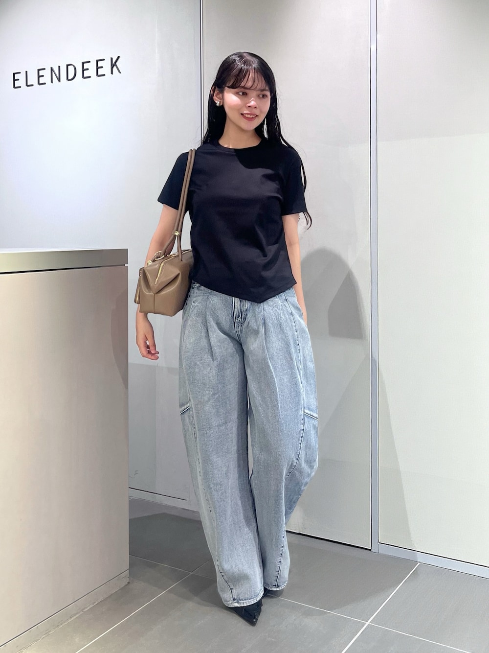 ブラック系のTシャツ/カットソー、ブルー系のデニムパンツ、ブラウン系のボストンバッグを着用したレディースの夏コーディネートの1枚目の写真