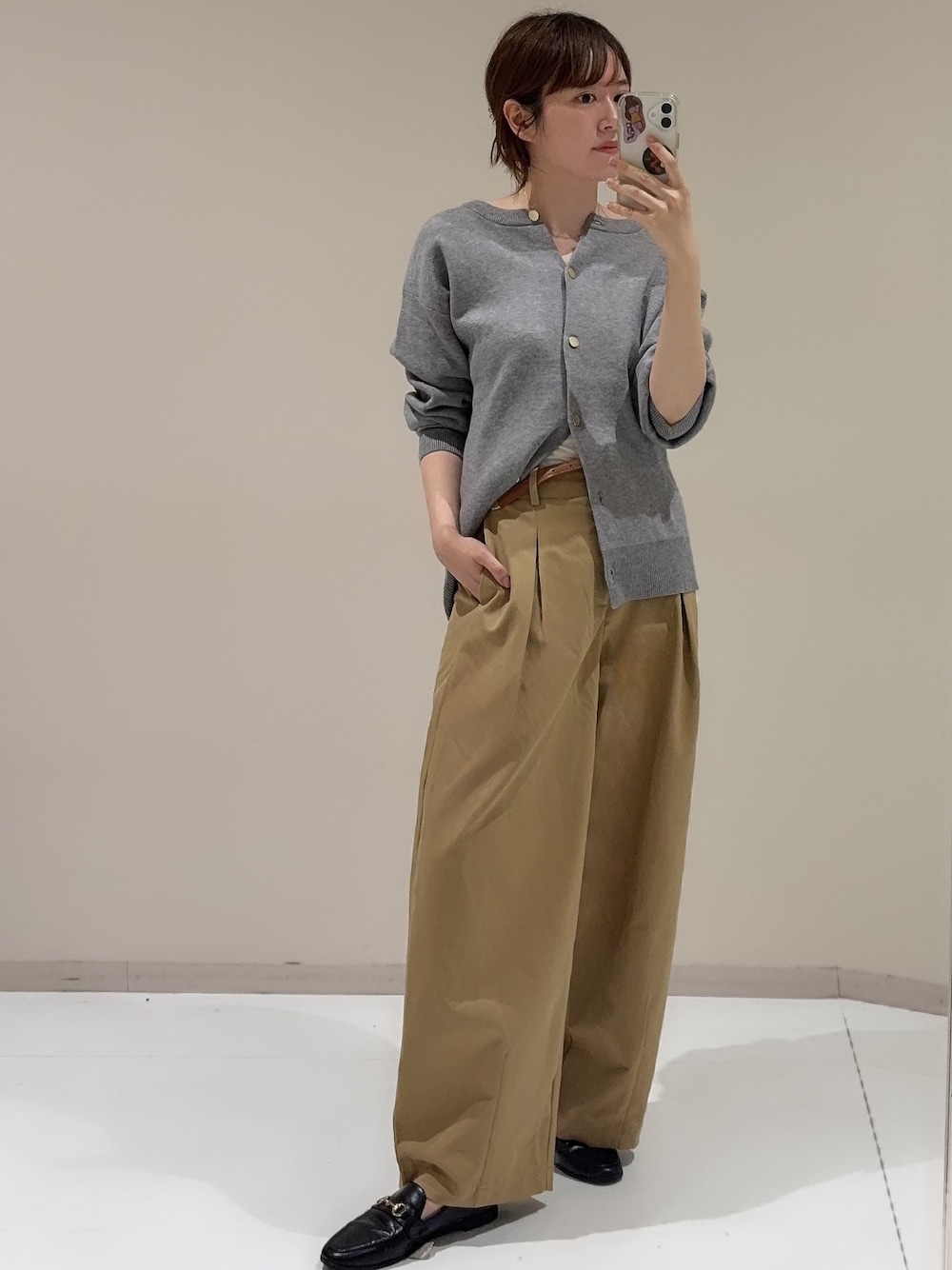 グレー系のカーディガン/ボレロ、ベージュ系のパンツを着用したレディースの秋コーディネートの1枚目の写真