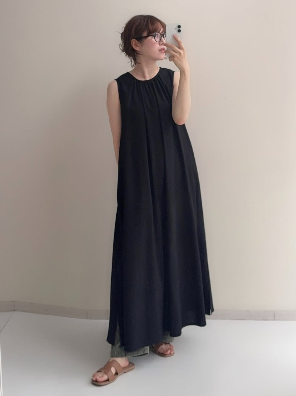 ブラック系のワンピース、ベージュ系のデニムパンツを着用したレディースの夏コーディネートの1枚目の写真