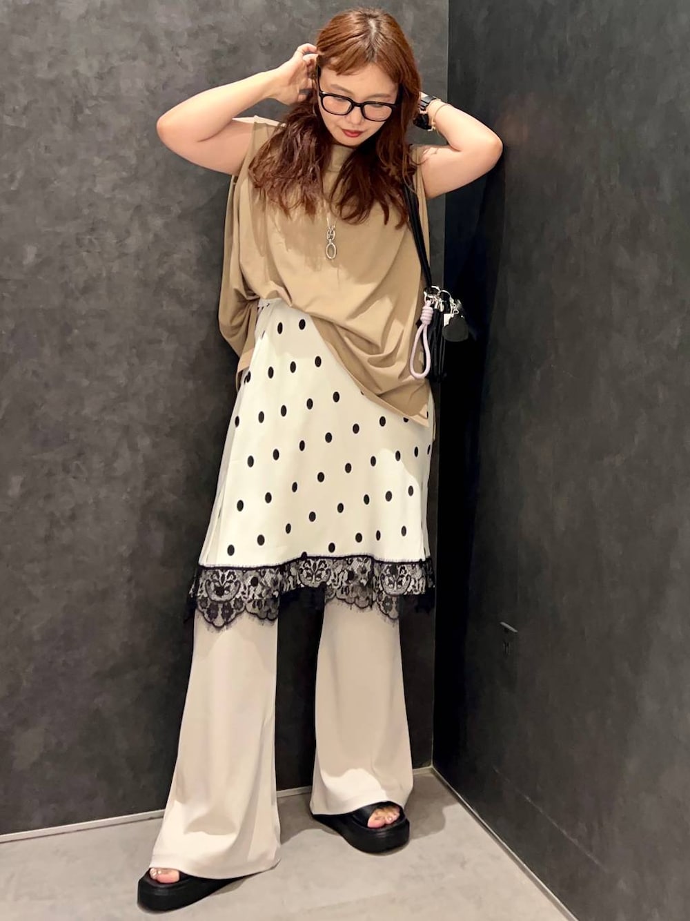 ベージュ系のTシャツ/カットソー、ブラック系のサンダル、ブラック系のショルダーバッグを着用したレディースの夏コーディネートの1枚目の写真