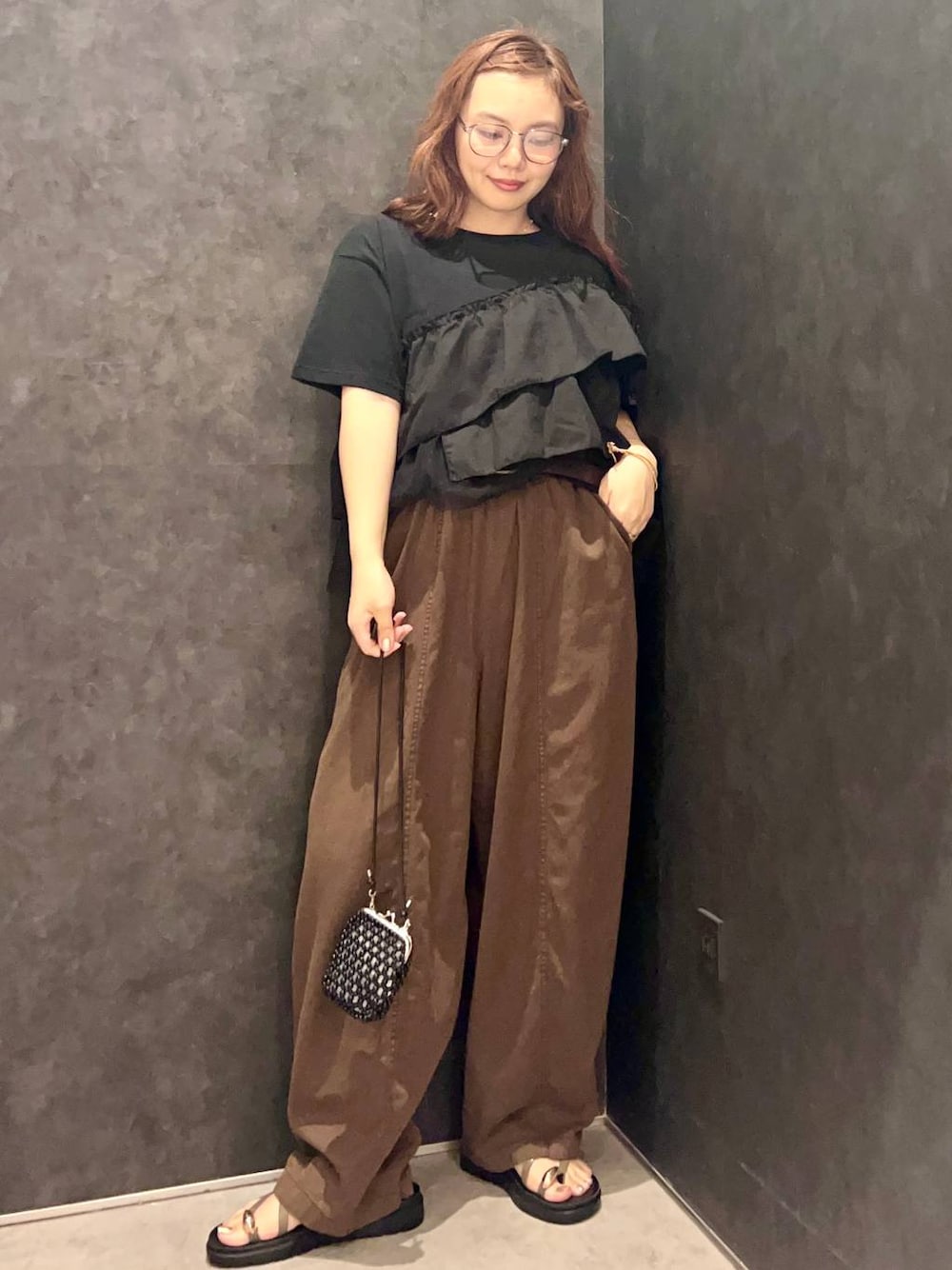 ブラウン系のその他パンツ、ブラウン系のサンダル、ブラック系のTシャツ/カットソーを着用したレディースの夏コーディネートの1枚目の写真