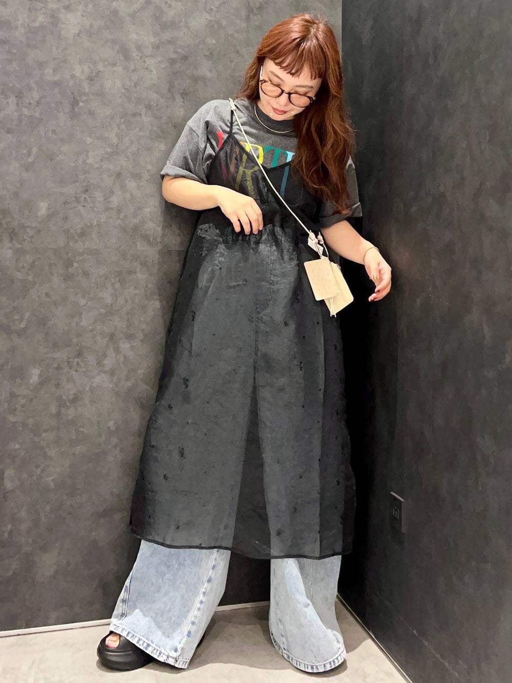 ブラック系のワンピース、グレー系のTシャツ/カットソー、ブルー系のデニムパンツを着用したレディースの夏コーディネートの1枚目の写真