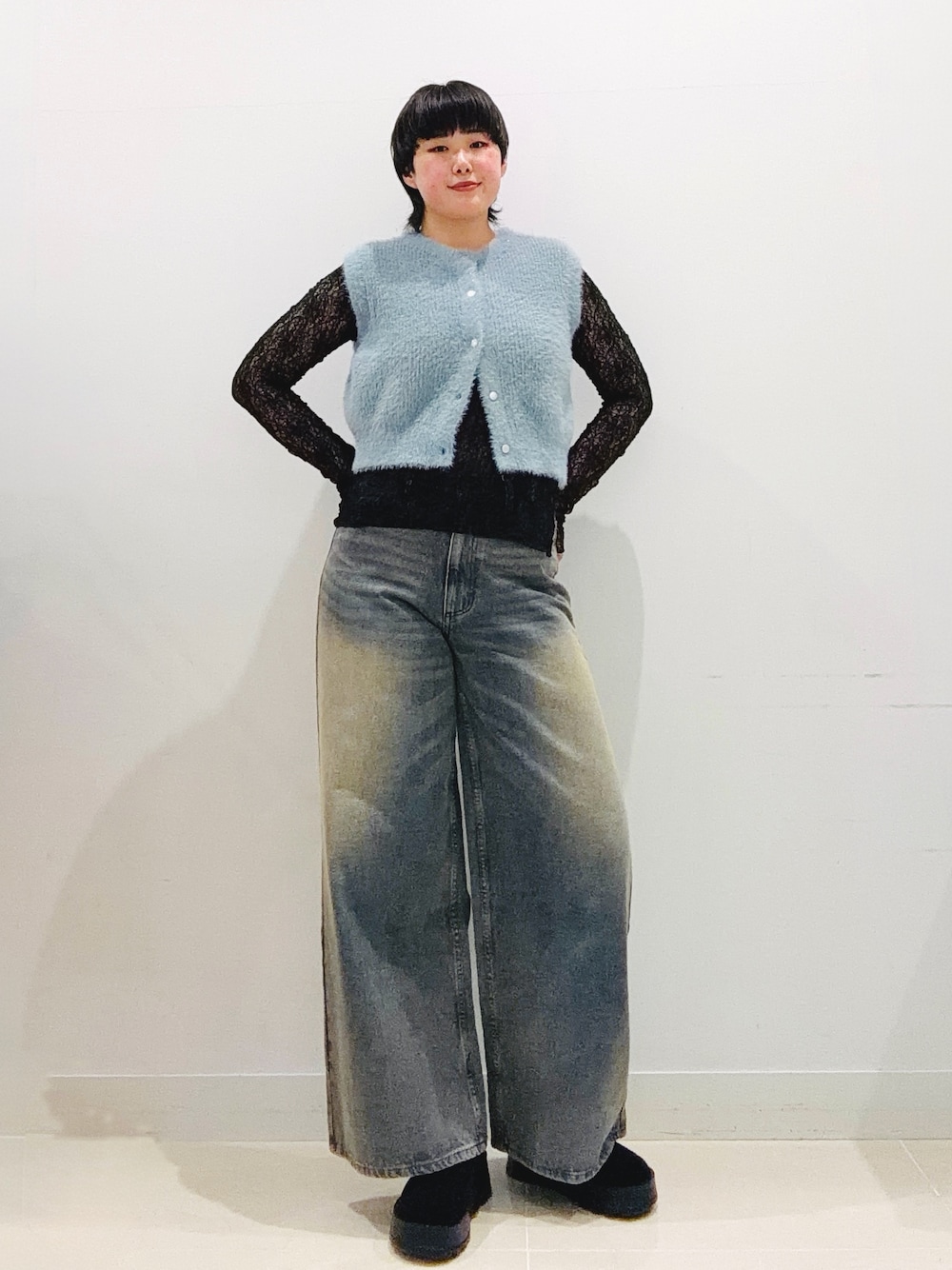 ブルー系のニット/セーター、ブラック系のTシャツ/カットソー、ブルー系のデニムパンツを着用したレディースの秋コーディネートの1枚目の写真