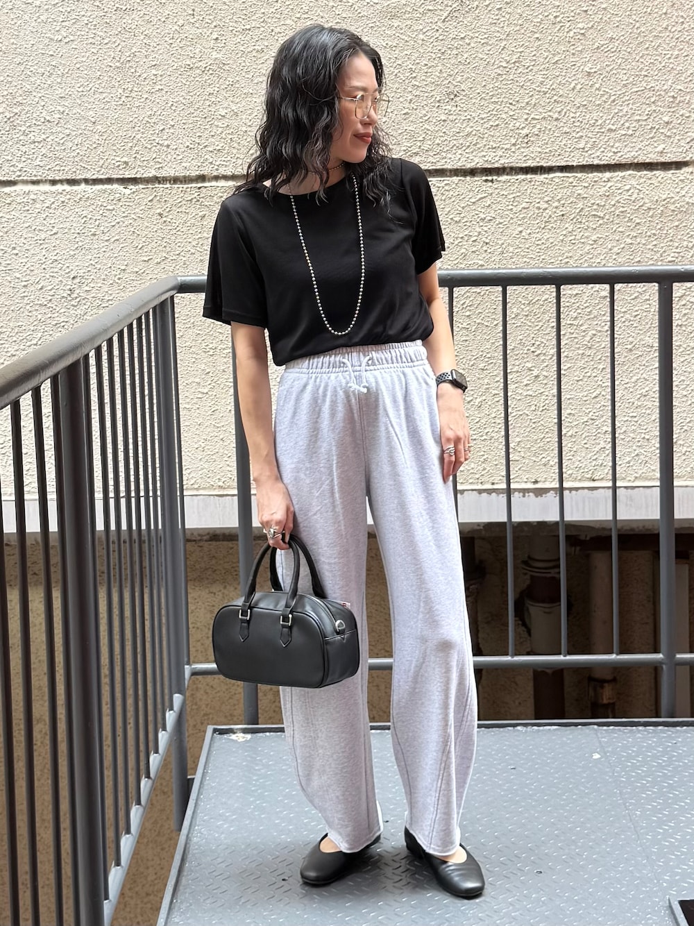 グレー系のその他パンツ、ブラック系のTシャツ/カットソー、ブラック系のショルダーバッグを着用したレディースの夏コーディネートの1枚目の写真