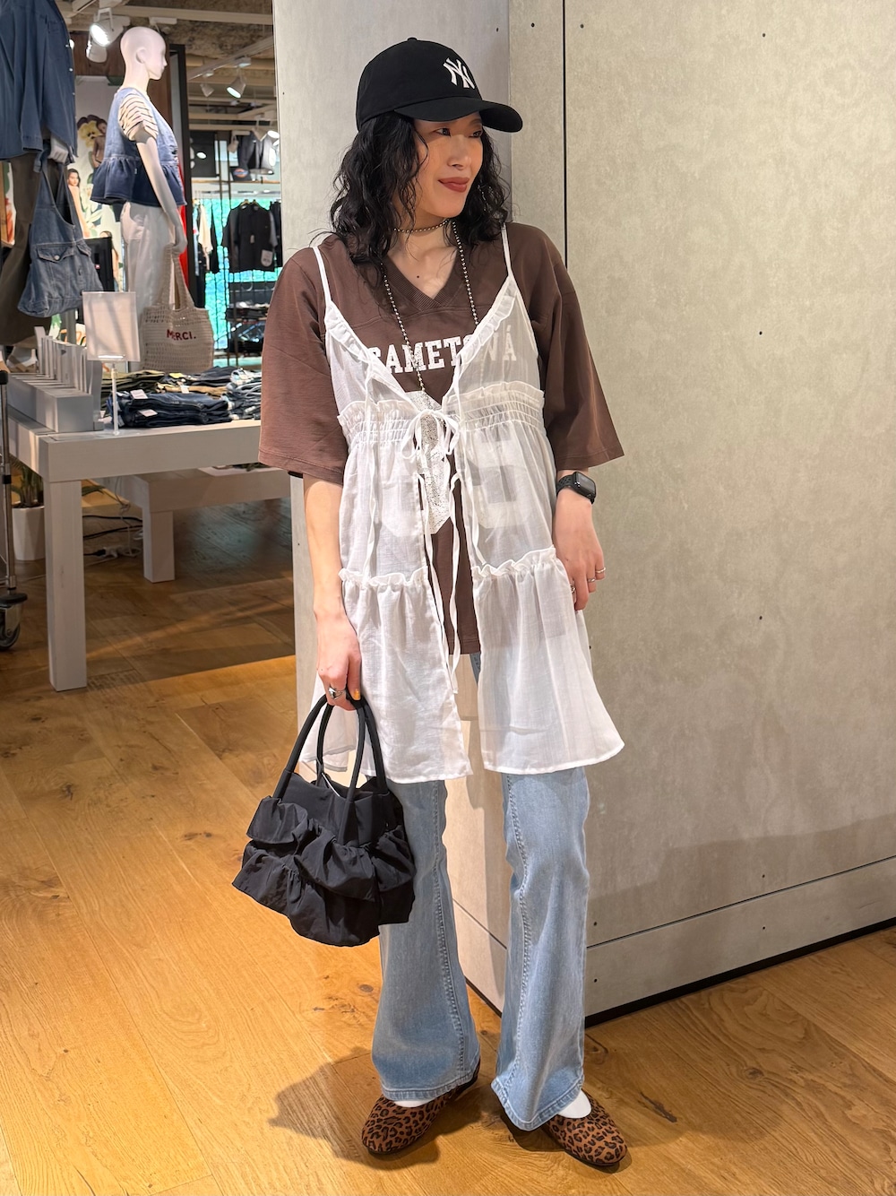 ブルー系のデニムパンツ、ホワイト系のベスト、ブラウン系のTシャツ/カットソーを着用したレディースの夏コーディネートの1枚目の写真