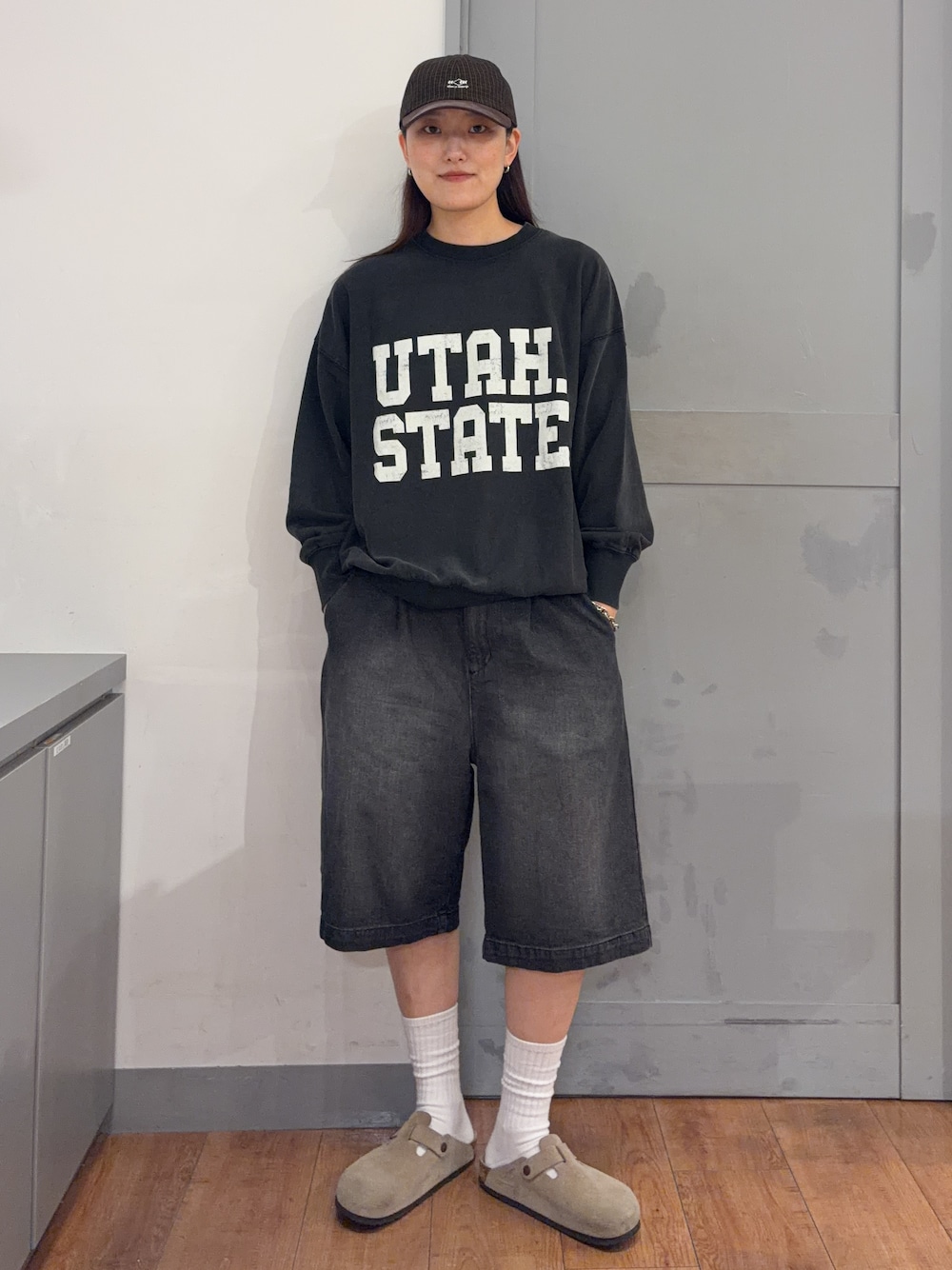 グレー系のスウェット、ブラック系のその他パンツ、ブラウン系のキャップを着用したレディースの秋コーディネートの1枚目の写真
