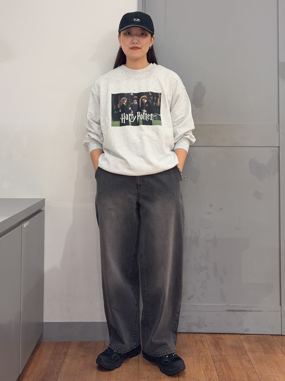 ベージュ系のニット/セーター、ブラック系のデニムパンツ、ブラック系のキャップを着用したレディースの秋コーディネートの1枚目の写真