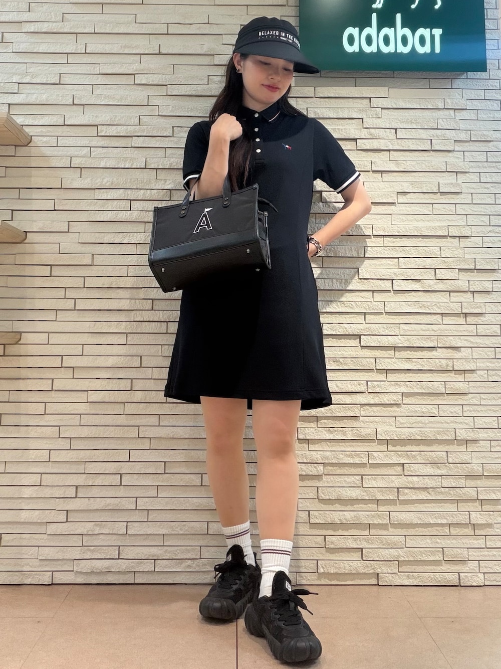 ブルー系のワンピース、ブラック系のトートバッグ、ブラック系のハットを着用したレディースの夏コーディネートの1枚目の写真
