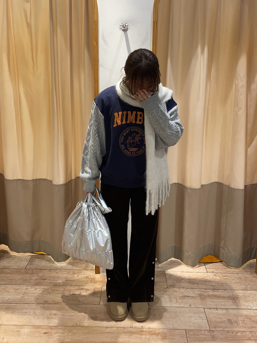 ホワイト系のハンドバッグ、ブラウン系のその他パンツ、ブルー系のTシャツ/カットソーを着用したレディースの秋コーディネートの1枚目の写真