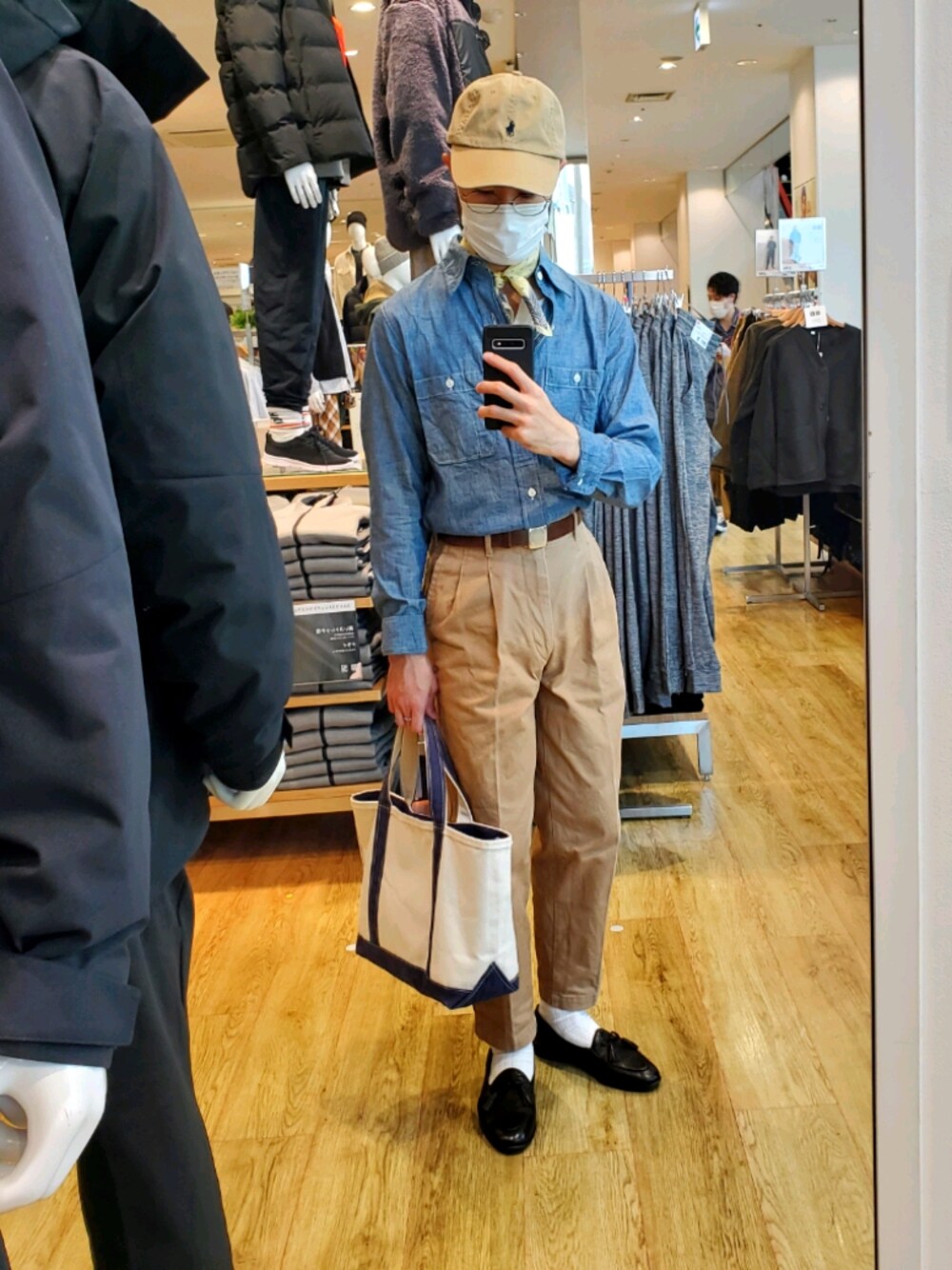 ブルー系のトートバッグ、ブラウン系のスリッポン、ブルー系のシャツ/ブラウスを着用したメンズの秋コーディネートの1枚目の写真