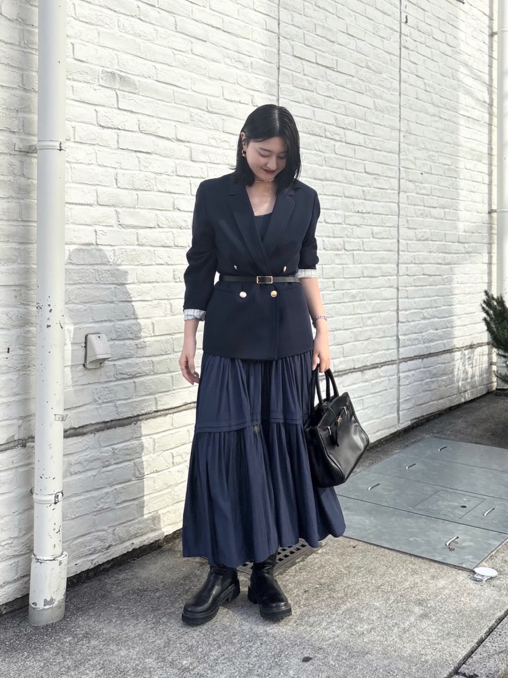 ブルー系のテーラードジャケット、ブルー系のワンピース、ブラック系のブーツを着用したレディースの秋コーディネートの1枚目の写真