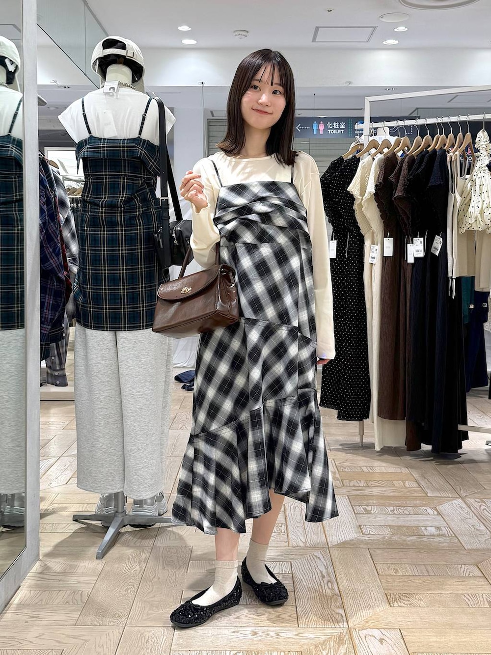 ブラウン系のボストンバッグ、ホワイト系のTシャツ/カットソー、グレー系のワンピースを着用したレディースの秋コーディネートの1枚目の写真